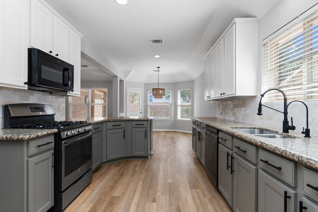 Your gourmet kitchen is beautifully appointed with deep custom stainless steel double sinks, elegant cabinet hardware, a custom pull-out kitchen faucet, and an abundance of quality finishes designed for both style and everyday convenience.
