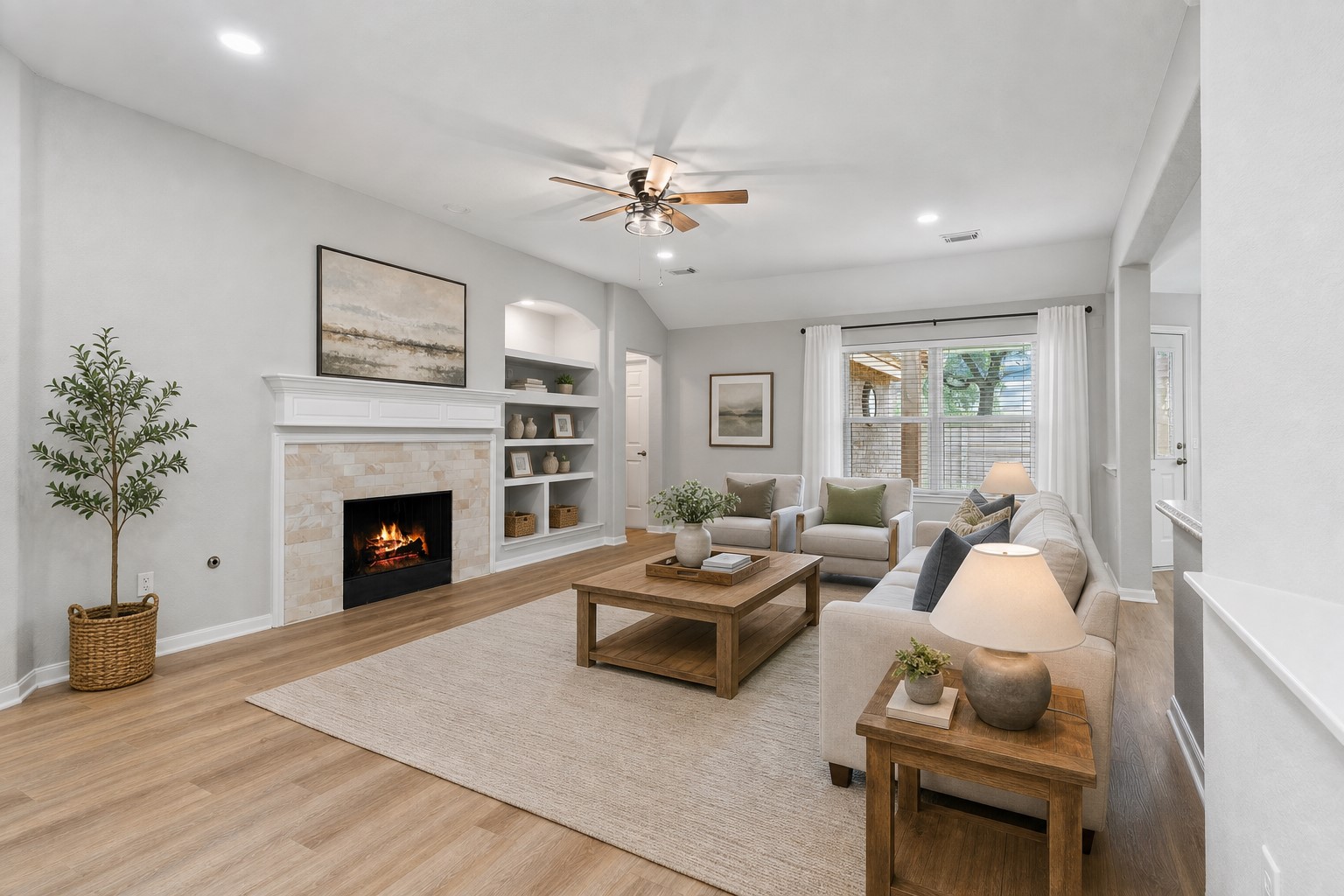 Step into the impressive family room featuring soaring ceilings, upgraded designer light fixtures, a custom built-in bookshelf, and beautiful wood-look luxury vinyl plank flooring. Notice the elegant two-tone interior paint that adds warmth and style throughout this exceptional home. Virtually Staged