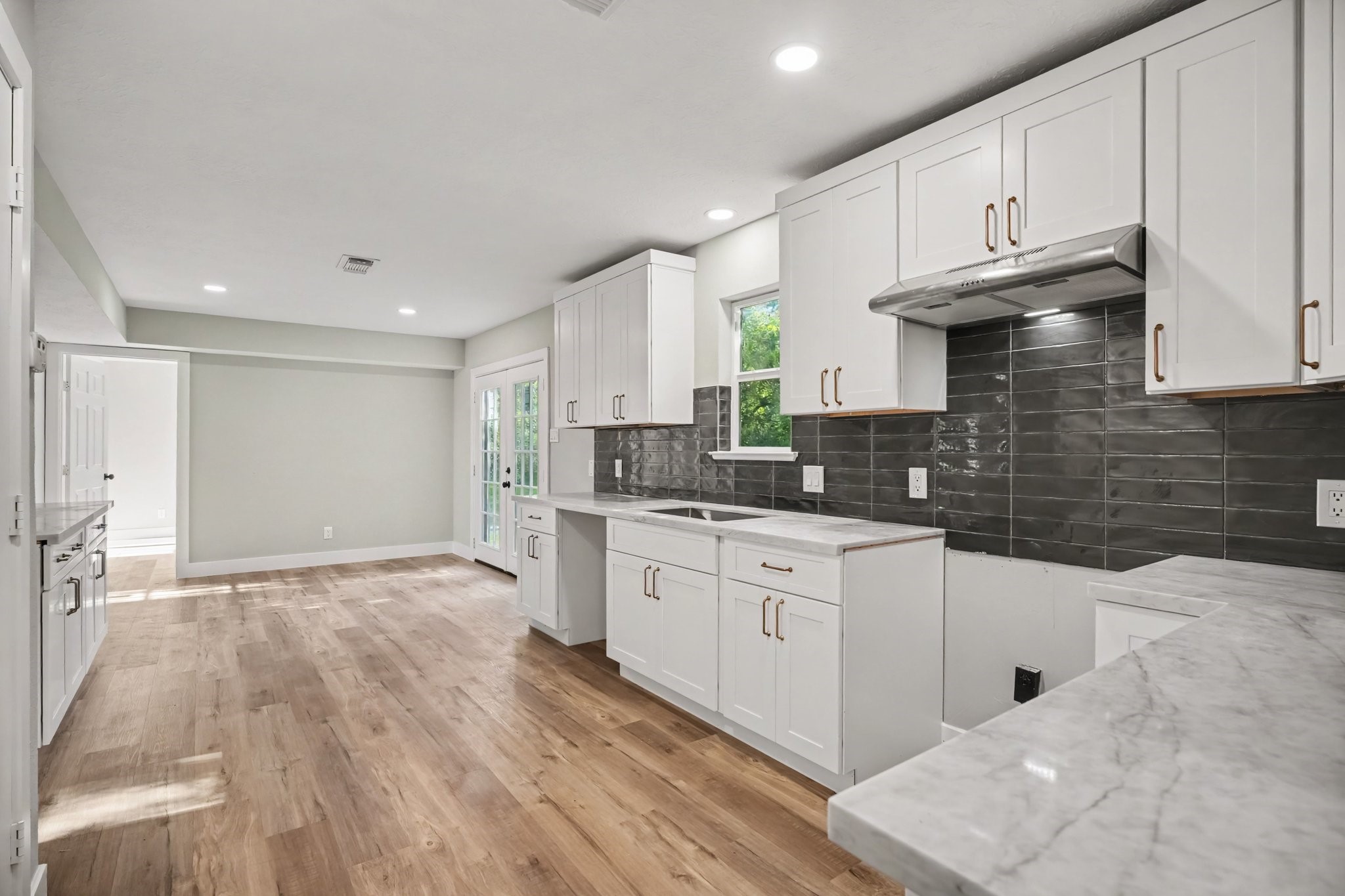 Beautiful updated kitchen from cabinets, flooring, handles, counter tops and backsplash