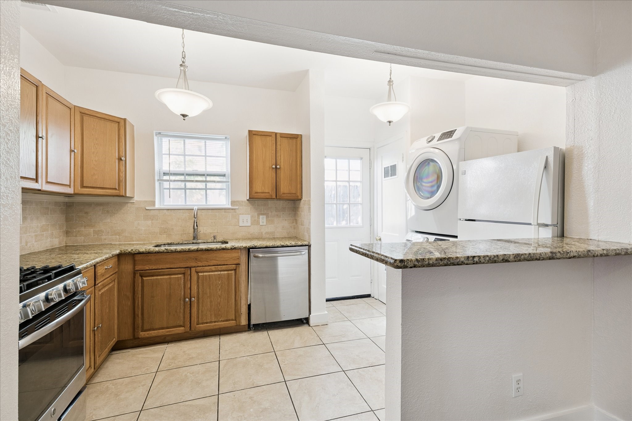 Recently updated kitchen with dishwasher, microwave, stacked washer and dryer and fridge. Beautiful granite countertops make it easy to entertain.
