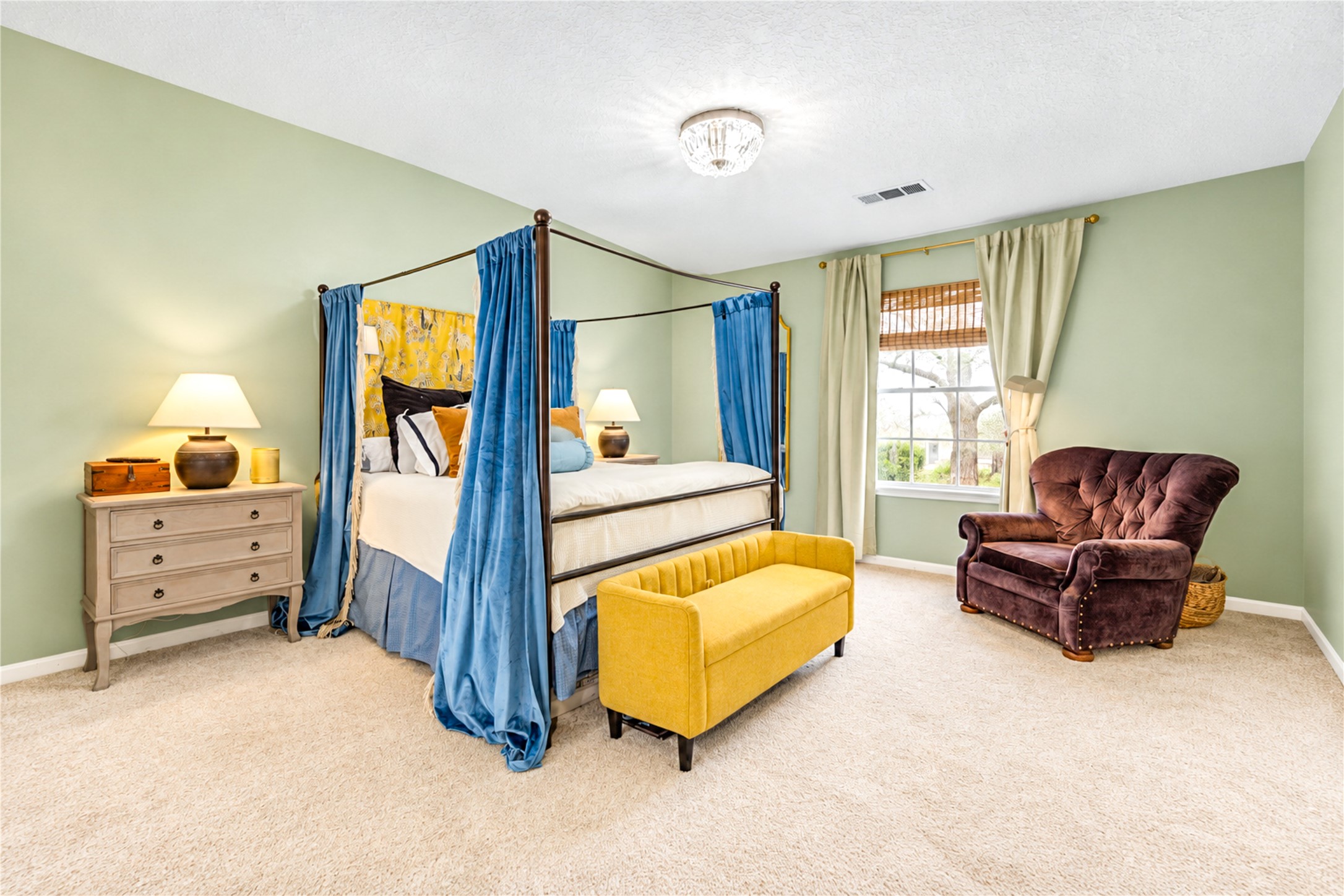 Escape to your own private retreat! This spacious second-floor primary bedroom offers a peaceful blend of comfort and designer charm, featuring soft, soothing wall colors, abundant natural light and plenty of room to relax. The elegant canopy bed showcases the room's generous proportions, while thoughtfully curated details create a serene atmosphere. The perfect place to unwind after a busy day and wake up feeling refreshed!