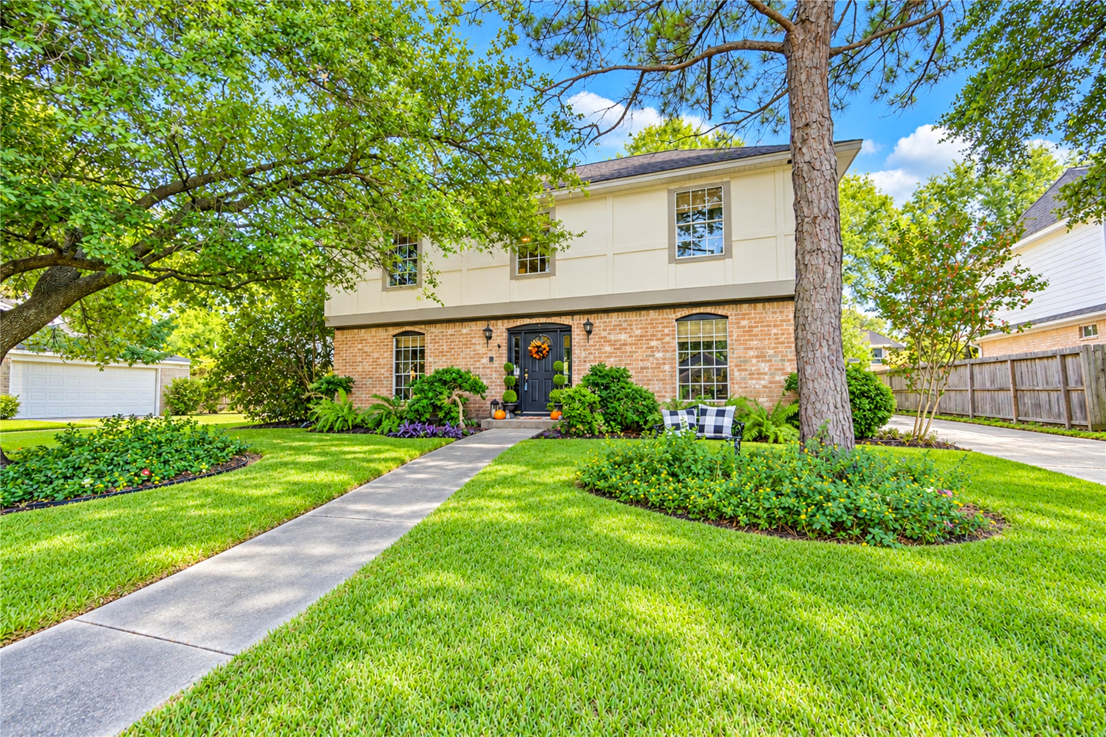 Picture-perfect curb appeal welcomes you home! This charming two-story home blends classic brick architecture with lush, manicured landscaping, mature shade trees and a beautifully framed front entry. A welcoming walkway winds through the vibrant green lawn, creating an inviting first impression. Nestled in the established Village West community, this is the kind of place where coming home feels like a retreat from the everyday hustle!