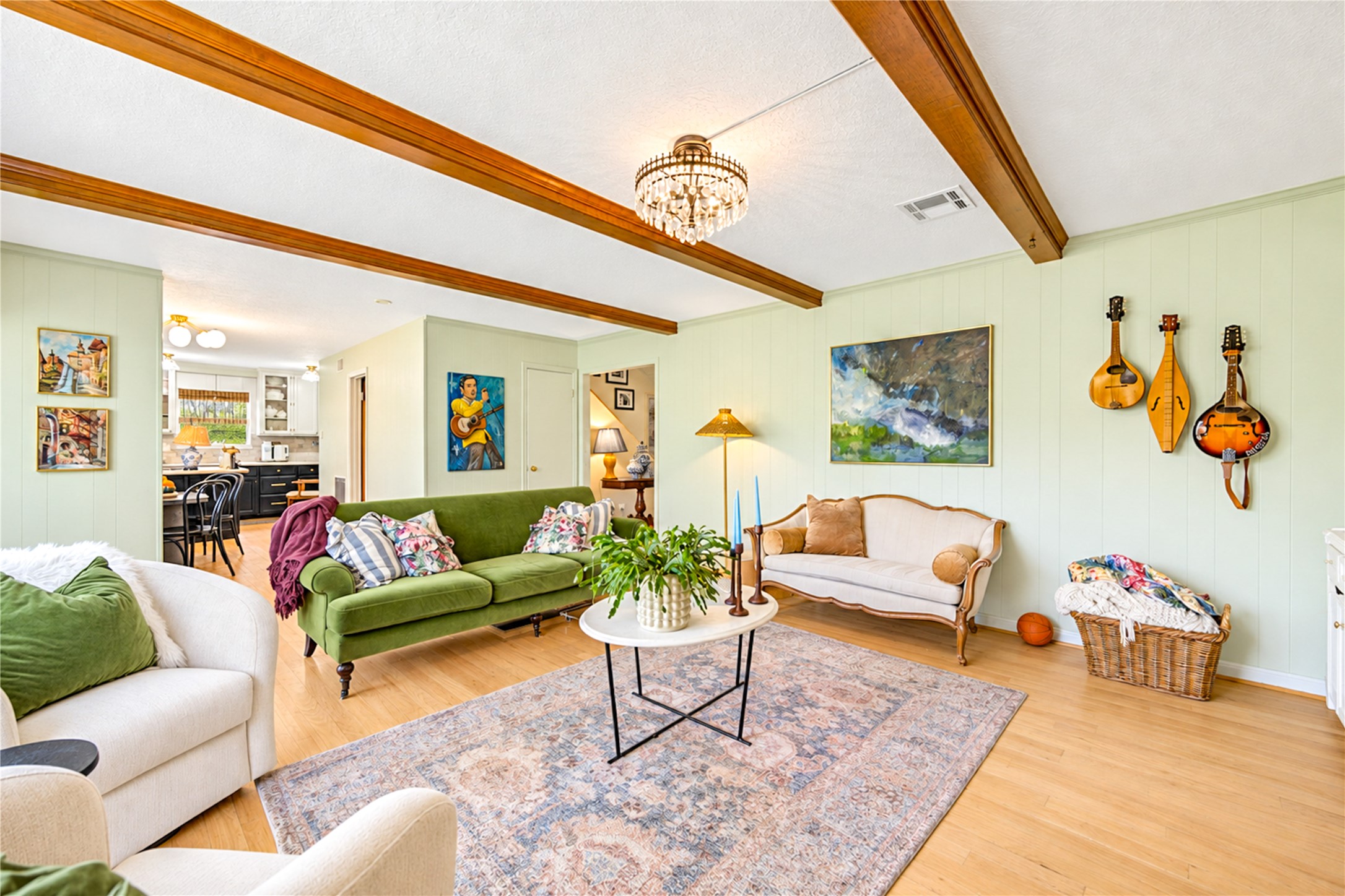 Designed for connection and comfortable everyday living! Soaring ceilings with exposed wood beams add warmth and character to this spacious living room, while beautiful wood floors and abundant natural light create an inviting atmosphere. The seamless flow into the open kitchen makes entertaining effortless, whether hosting lively gatherings, sharing casual conversations while preparing dinner or simply enjoying time at home. A perfect blend of style, comfort and functionality!