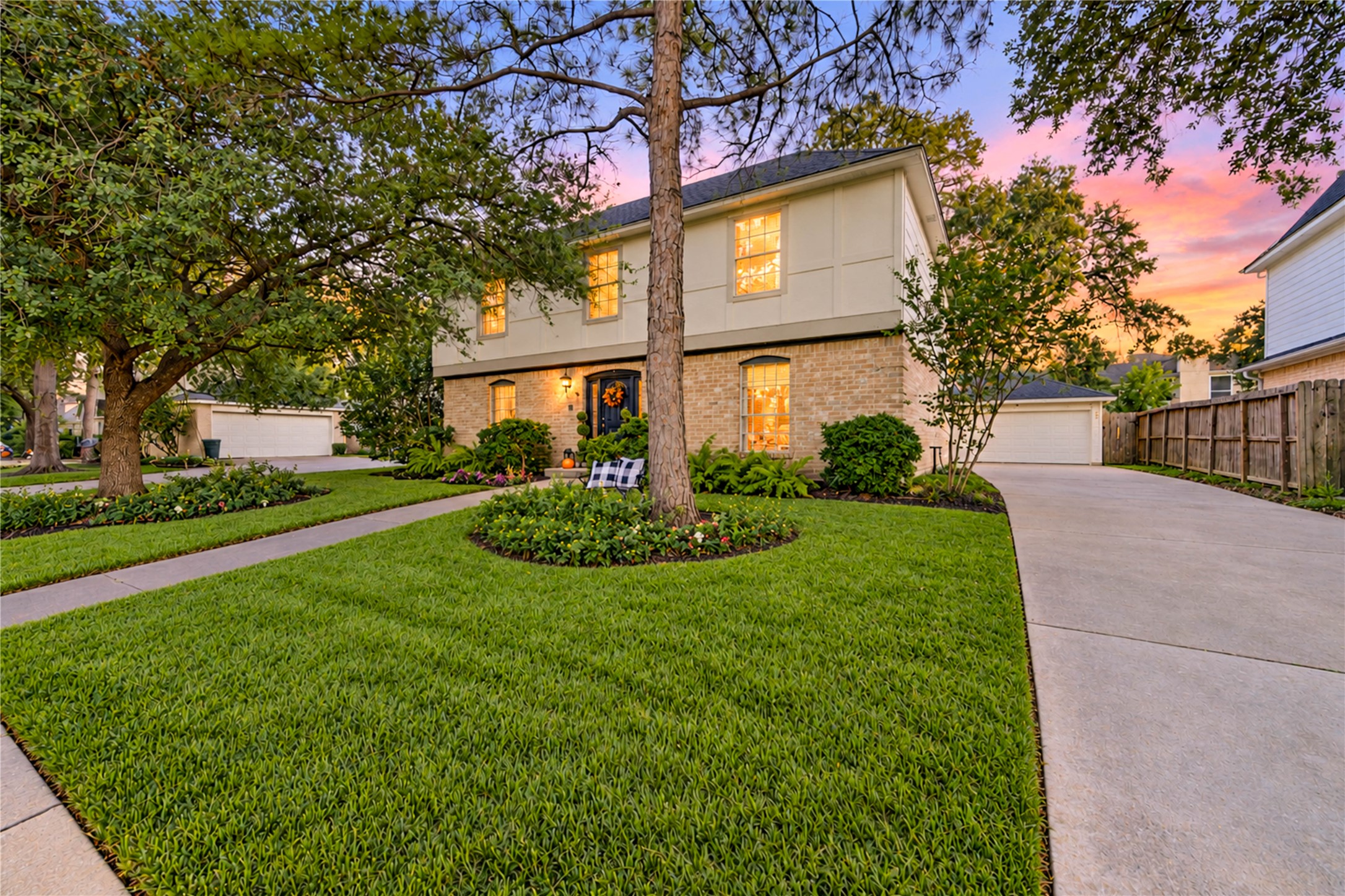 Come home to timeless charm and a welcoming neighborhood atmosphere! This beautiful two-story home features a sweeping driveway, lush manicured lawn and mature trees that frame its classic brick exterior. As evening falls, the warm glow from the windows creates an inviting scene, while the spacious front yard adds to the home's picturesque curb appeal. A lovely place to begin and end each day in the heart of Village West!