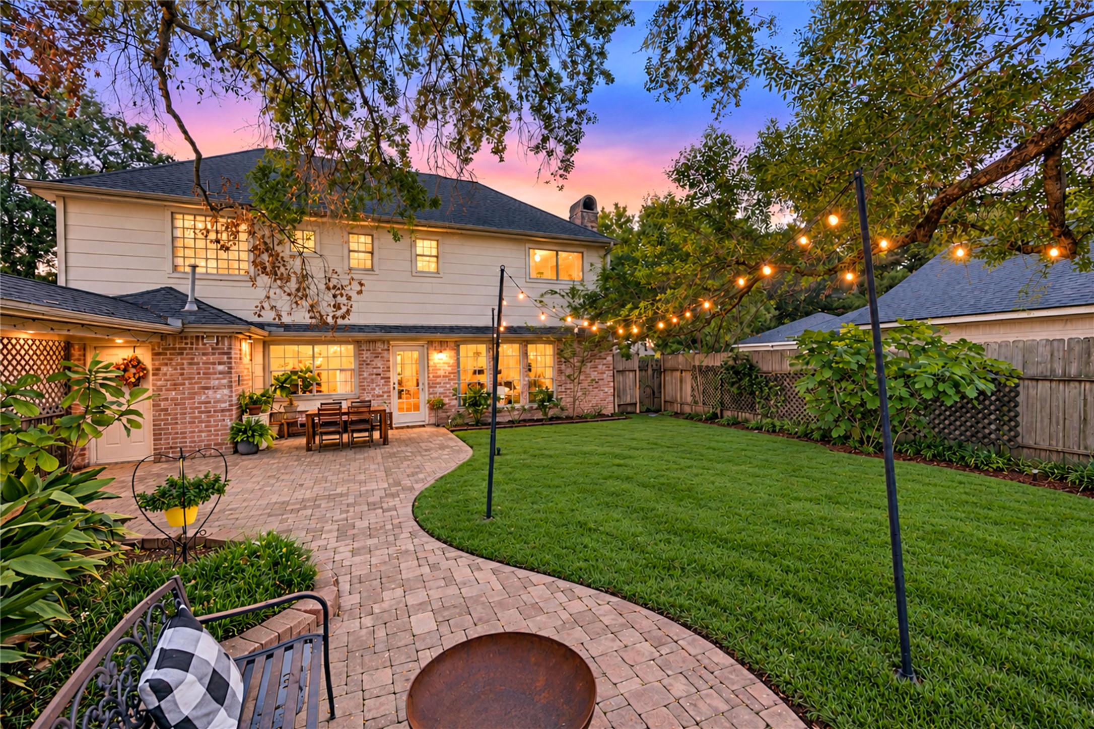 An outdoor retreat designed for making memories! This expansive fenced backyard offers a beautiful blend of lush green lawn, mature shade trees and an impressive brick paver patio. Imagine weekend cookouts, outdoor games, leisurely afternoons in the shade and magical evenings gathered with friends beneath the sunset sky. With room to entertain, play or simply unwind, this backyard brings the best of outdoor living right to your doorstep!