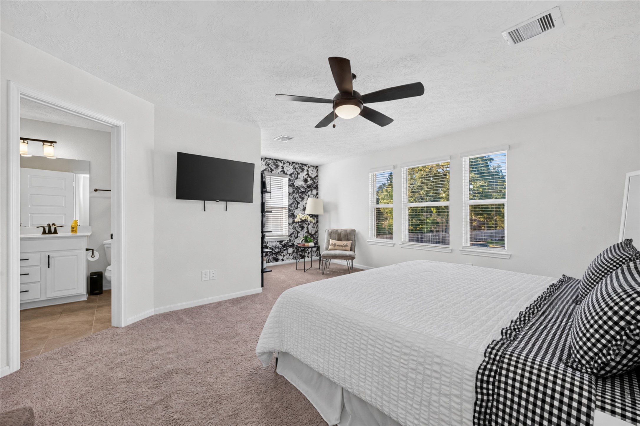 This spacious primary suite has room for both relaxation and a comfortable sitting area. Imagine starting your morning with a favorite book or winding down in your own peaceful retreat.