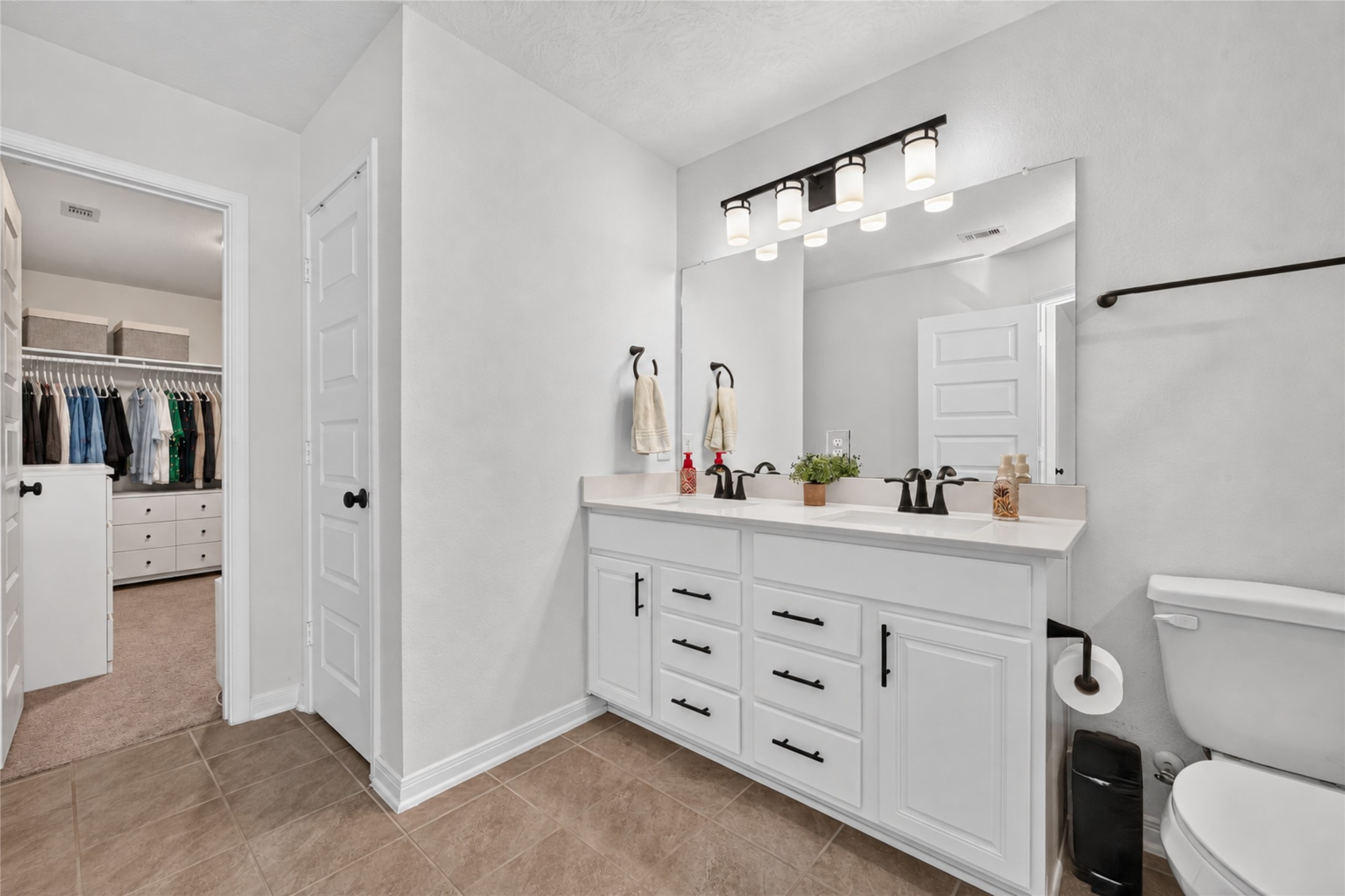 Start your morning with the convenience of a spacious vanity featuring generous countertop space and storage. The bright finishes create an inviting atmosphere for your daily routine.
