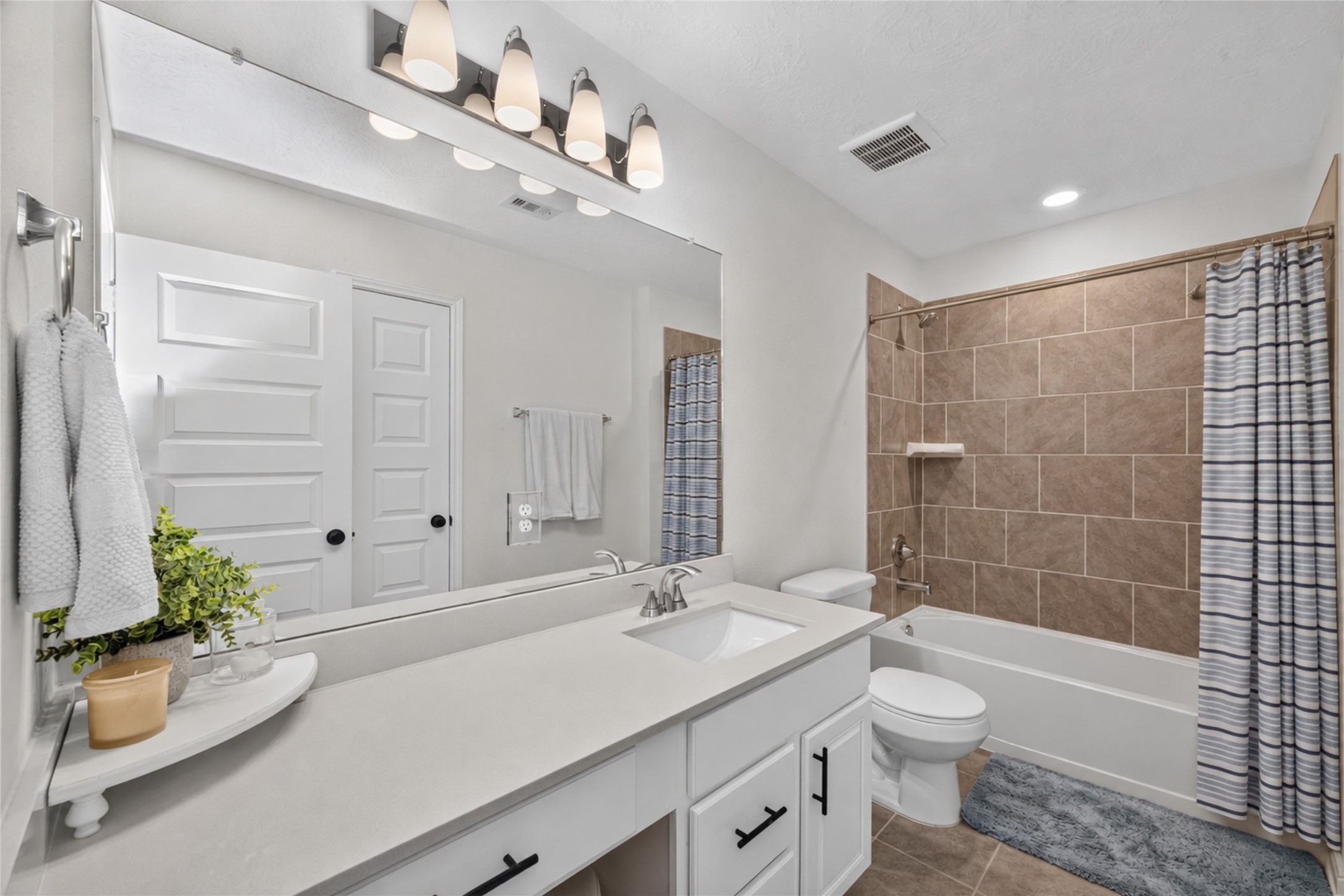 The upstairs bathroom features a spacious vanity and a tub-and-shower combination. Its practical layout and attractive finishes provide both comfort and convenience for everyday routines.