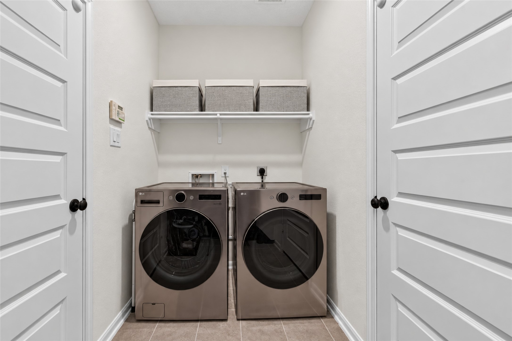 Make everyday routines more convenient with a dedicated laundry space featuring overhead shelving. The practical layout offers room to organize laundry supplies and keep essentials within easy reach.