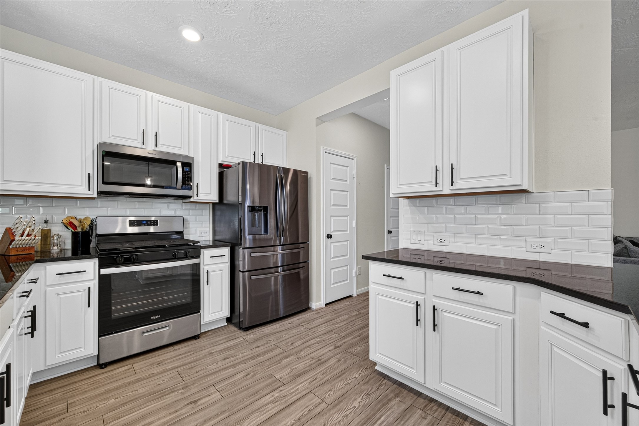 Preparing meals is a breeze with a gas range, built-in microwave, and ample counter space. Bright cabinetry and coordinated finishes create a warm, inviting kitchen, perfect for quick breakfasts or memorable dinners.