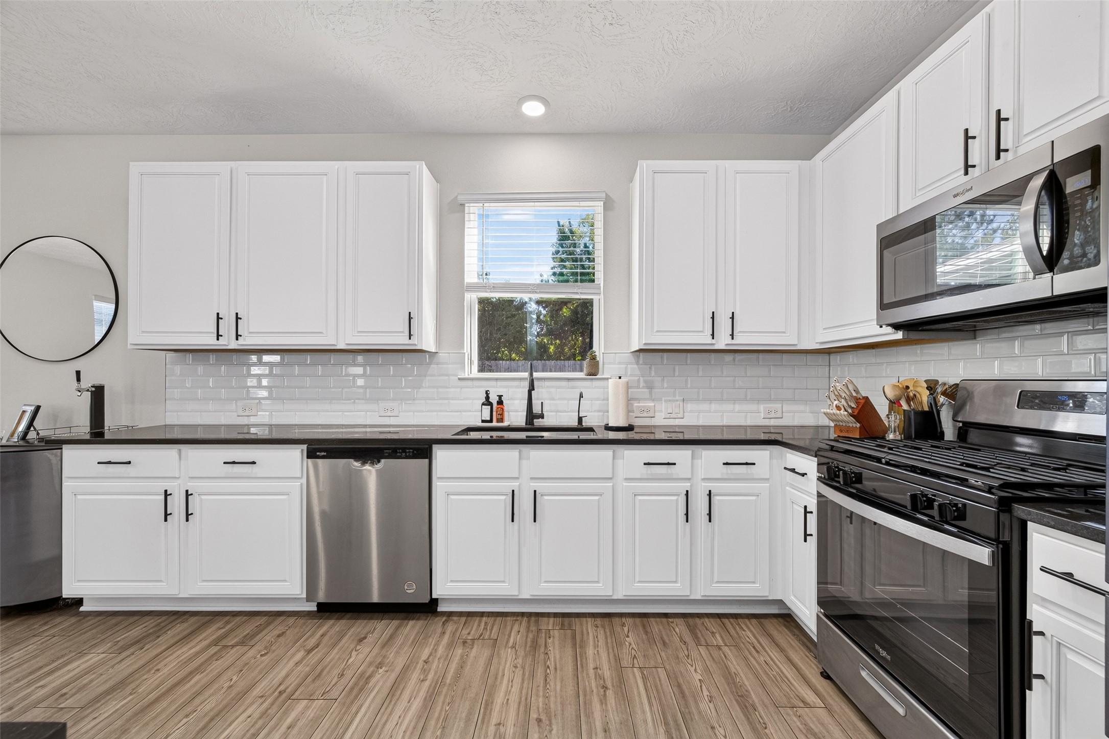 Create your favorite meals in this attractive kitchen featuring white cabinetry, stainless steel appliances, and generous counter space. The combination of stylish finishes and practical storage makes cooking and entertaining a pleasure.