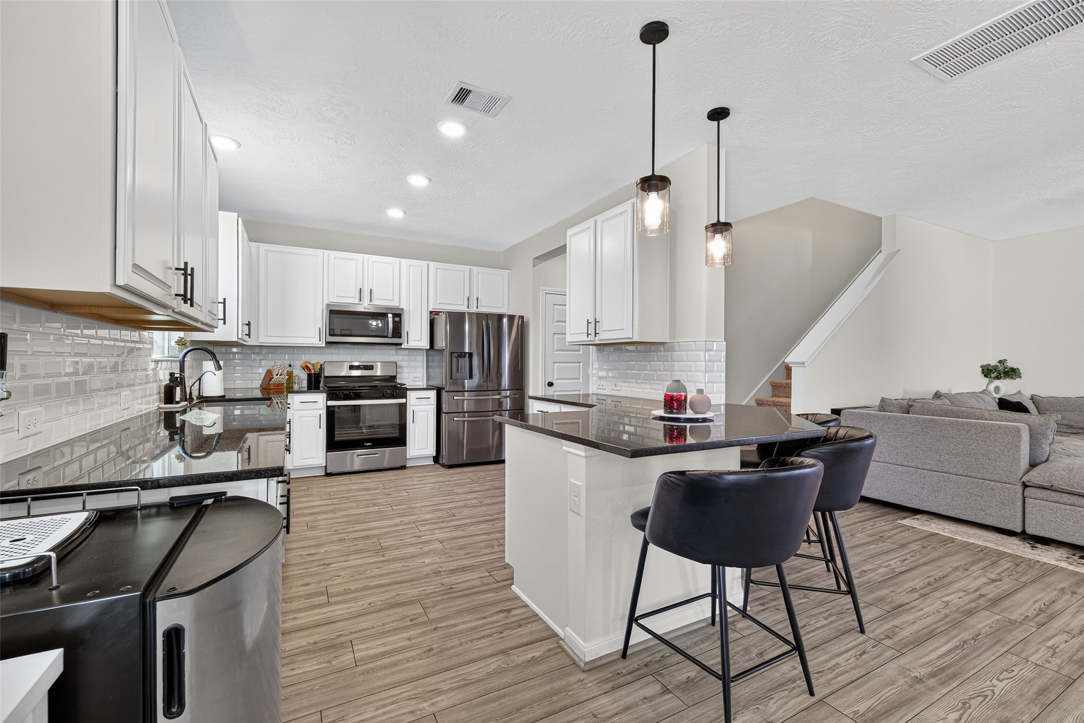Bring your favorite recipes to life in this bright kitchen featuring white cabinetry, stainless steel appliances, and a spacious island. Pendant lighting adds a stylish touch to a space designed for cooking, casual dining, and entertaining. Bring your favorite recipes to life in this bright kitchen featuring white cabinetry, stainless steel appliances, and a spacious island. Pendant lighting adds a stylish touch to a space designed for cooking, casual dining, and entertaining.