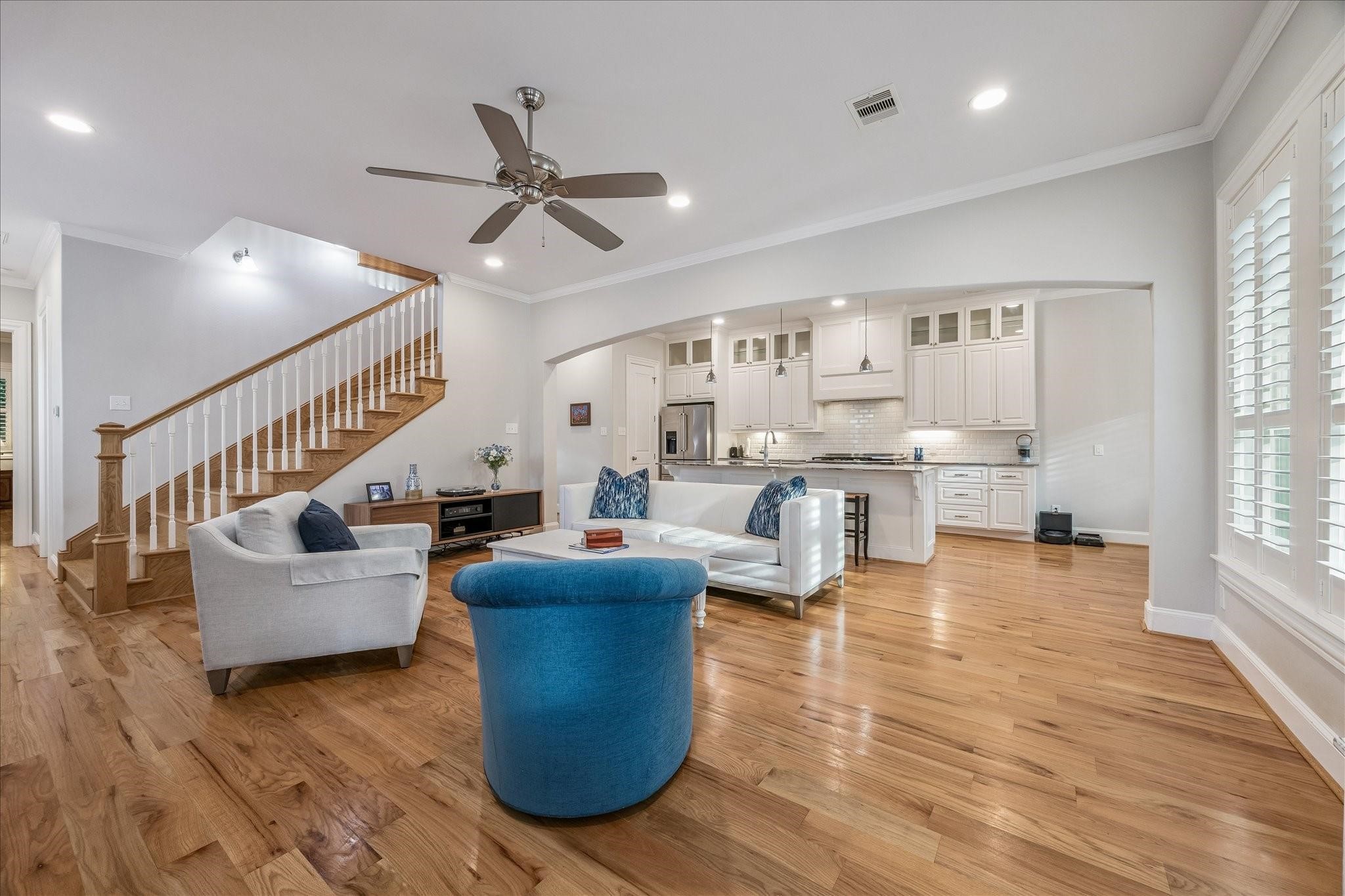 Step inside to this spacious, open-concept living area featuring warm hardwood floors and high ceilings, creating a welcoming atmosphere Step inside to this spacious, open-concept living area featuring warm hardwood floors and high ceilings, creating a welcoming atmosphere