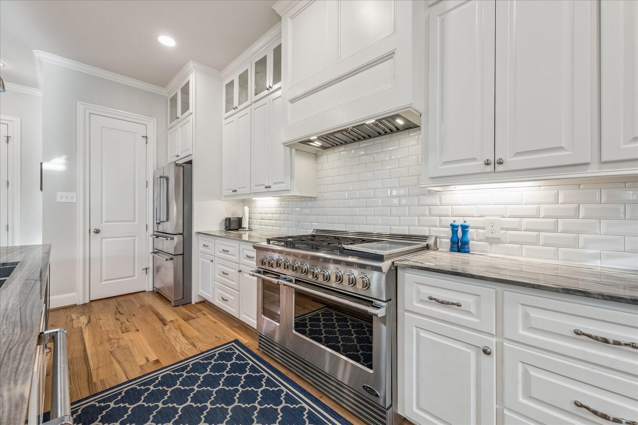 Double oven with a 6 burner gas range, griddle and custom vent hood for every cook's dream.