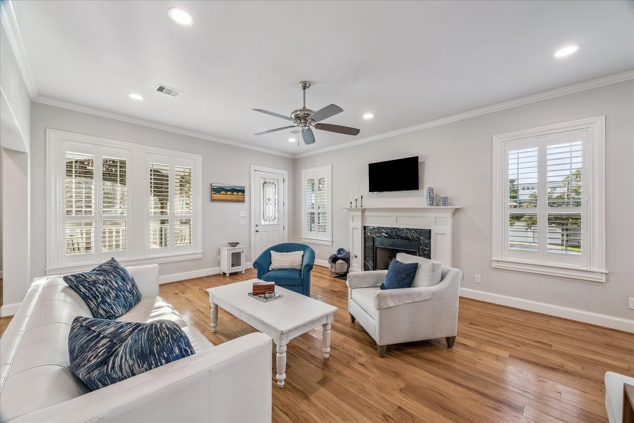 The space illuminates with tons of natural lighting from the large windows with Plantation shutters throughout the home