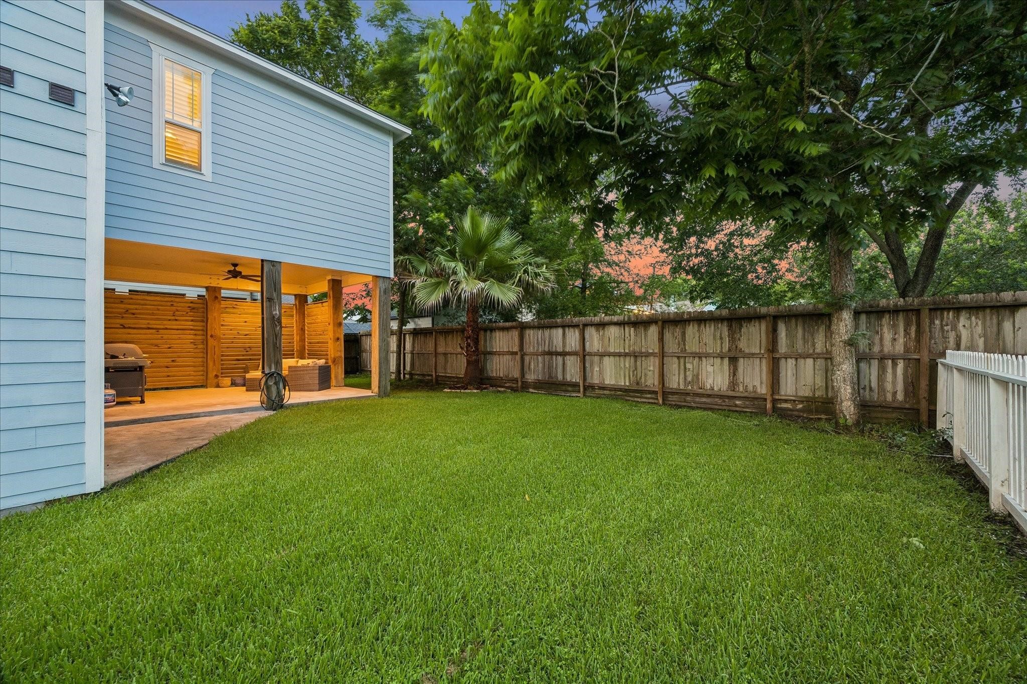 A lush, green side yard with room for a pool, pets or play