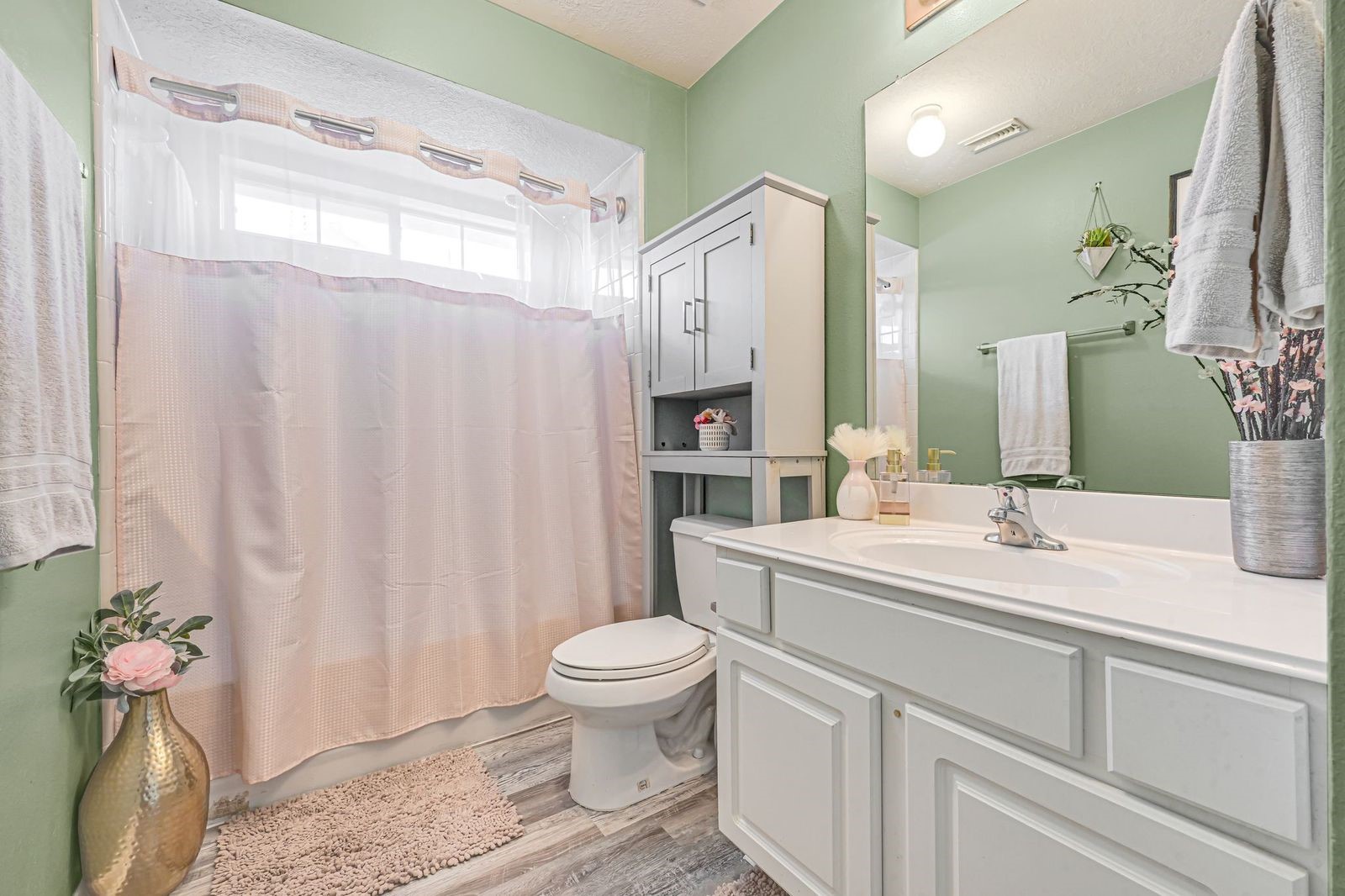 Hall bathroom with shower tub combo between bedrooms 2 and 3 with updated flooring
