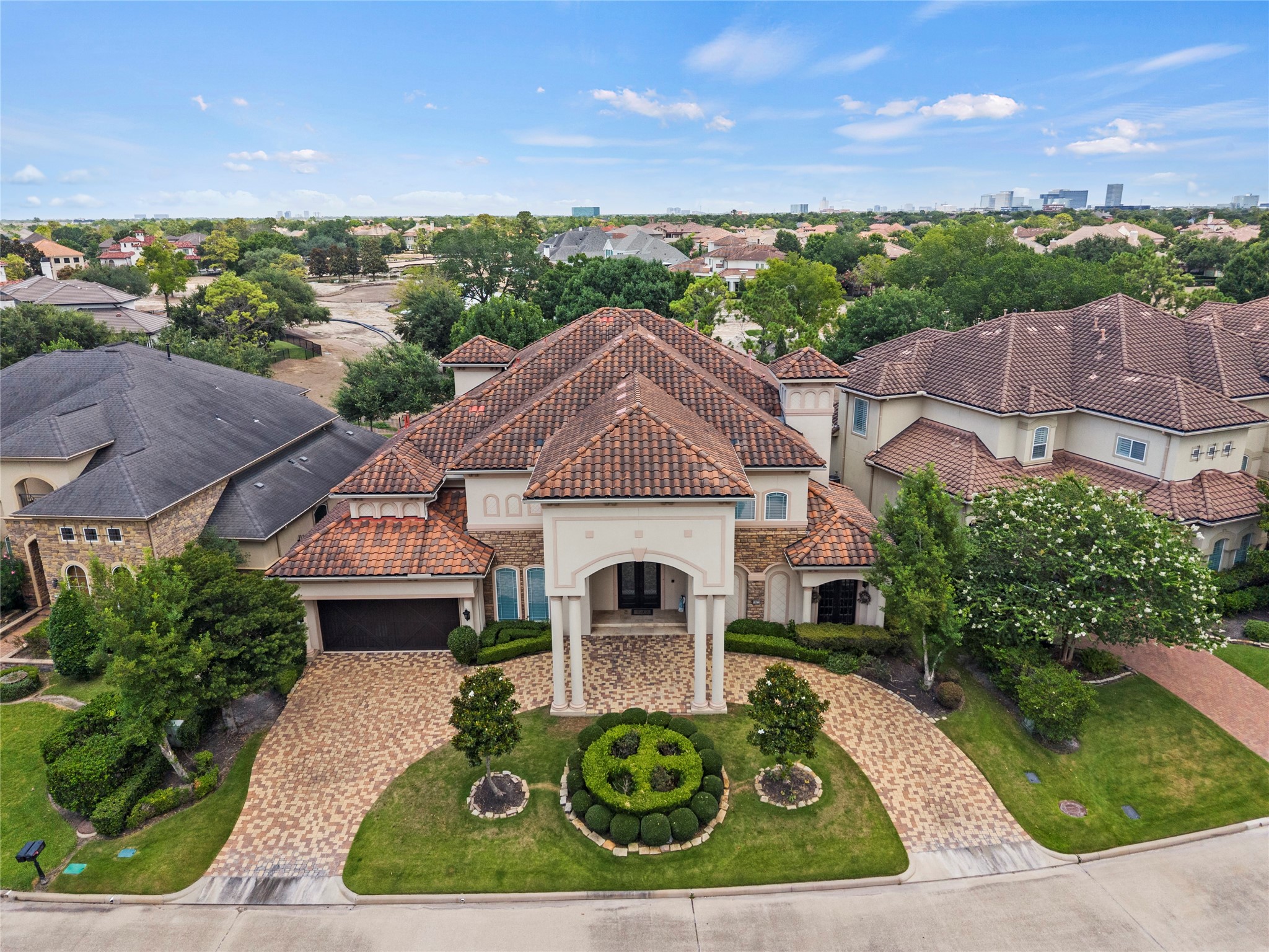 Elevated aerial view showcases the residences impressive scale, distinctive tile roofline, circular driveway, and beautifully maintained grounds.