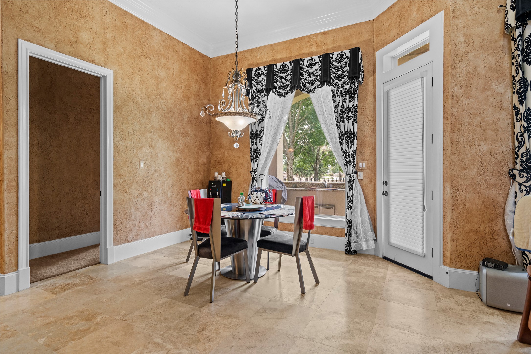 Charming breakfast area featuring elegant pendant lighting, a large picture window, and direct access to the outdoor living space.