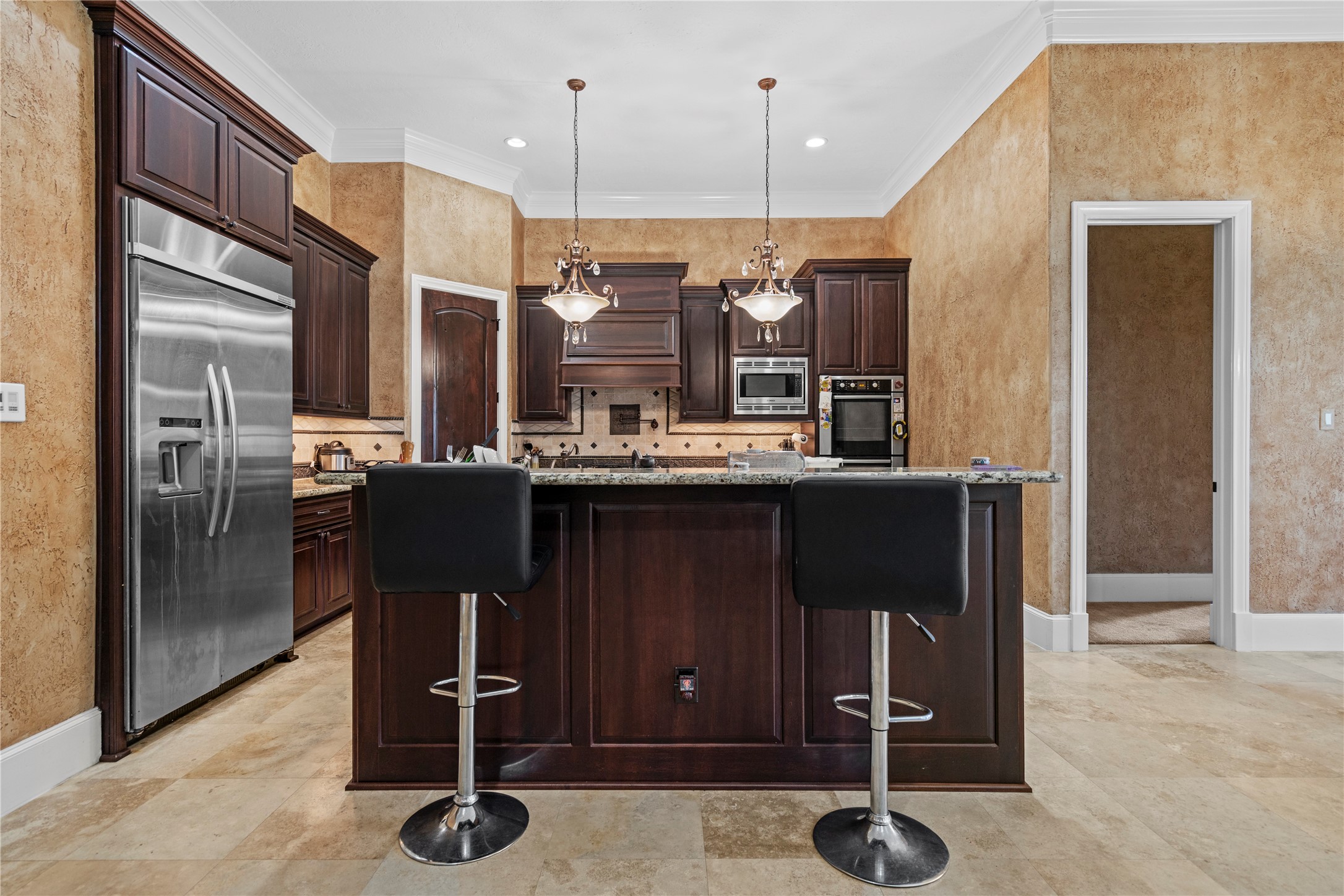 This kitchen with rich finishes, ample storage, and a large island that serves as a natural gathering spot.
