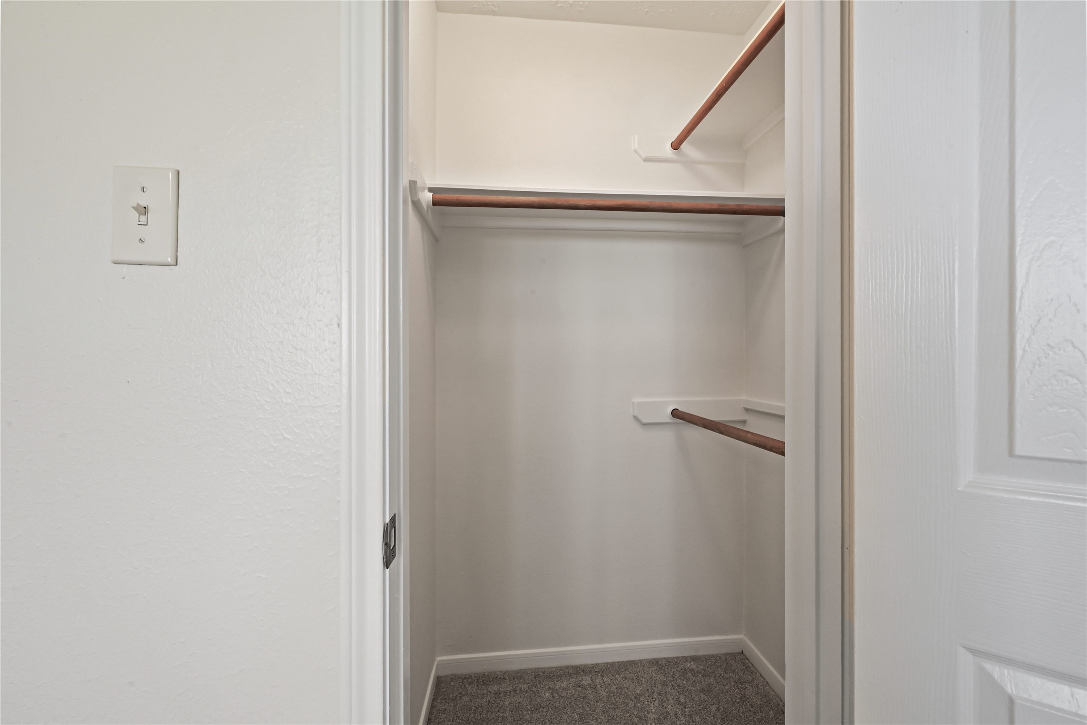 Spacious walk-in closet with ample hanging space and neutral tones for a clean, organized look.