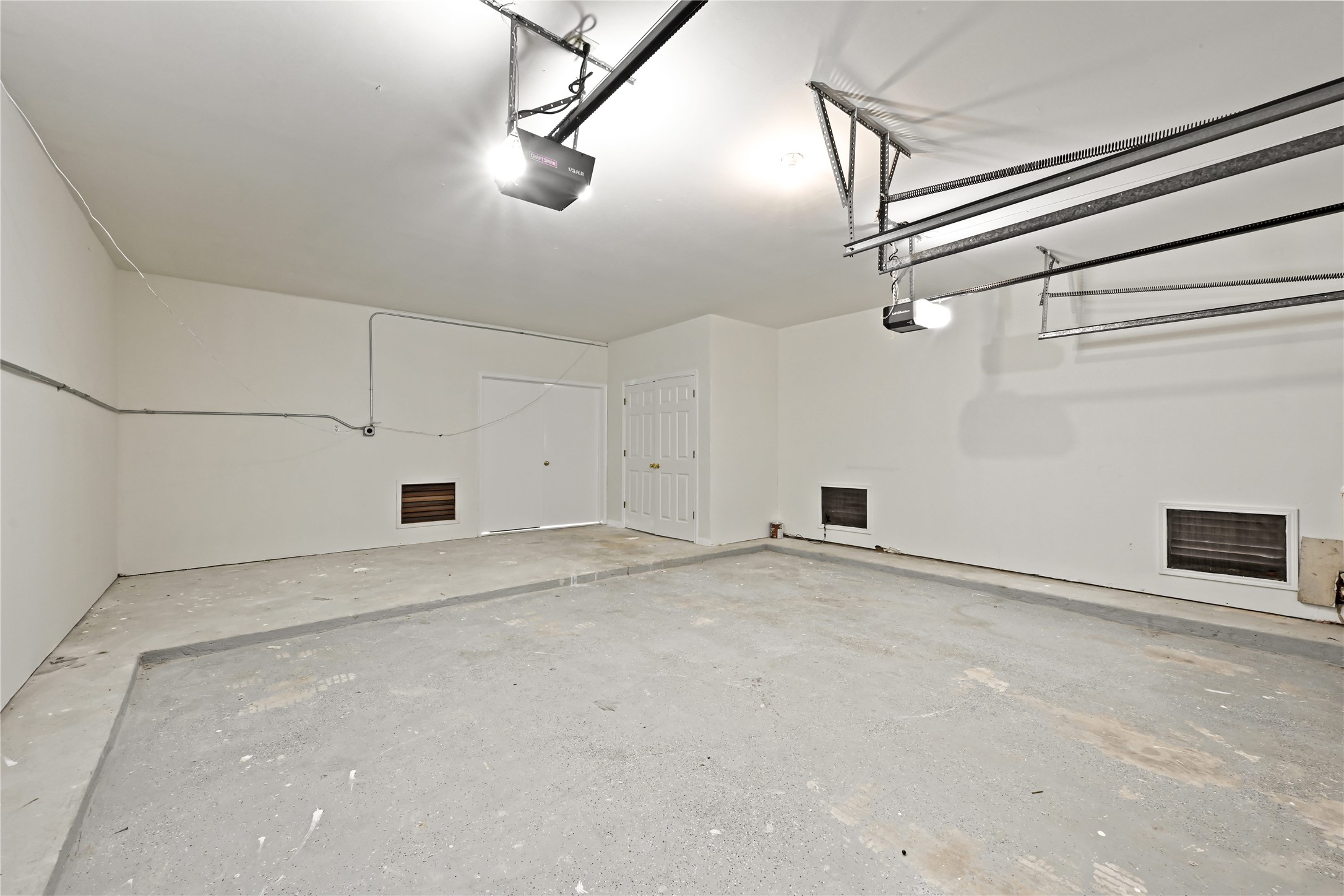 Spacious and clean garage with high ceilings, ample lighting, and convenient storage potential.