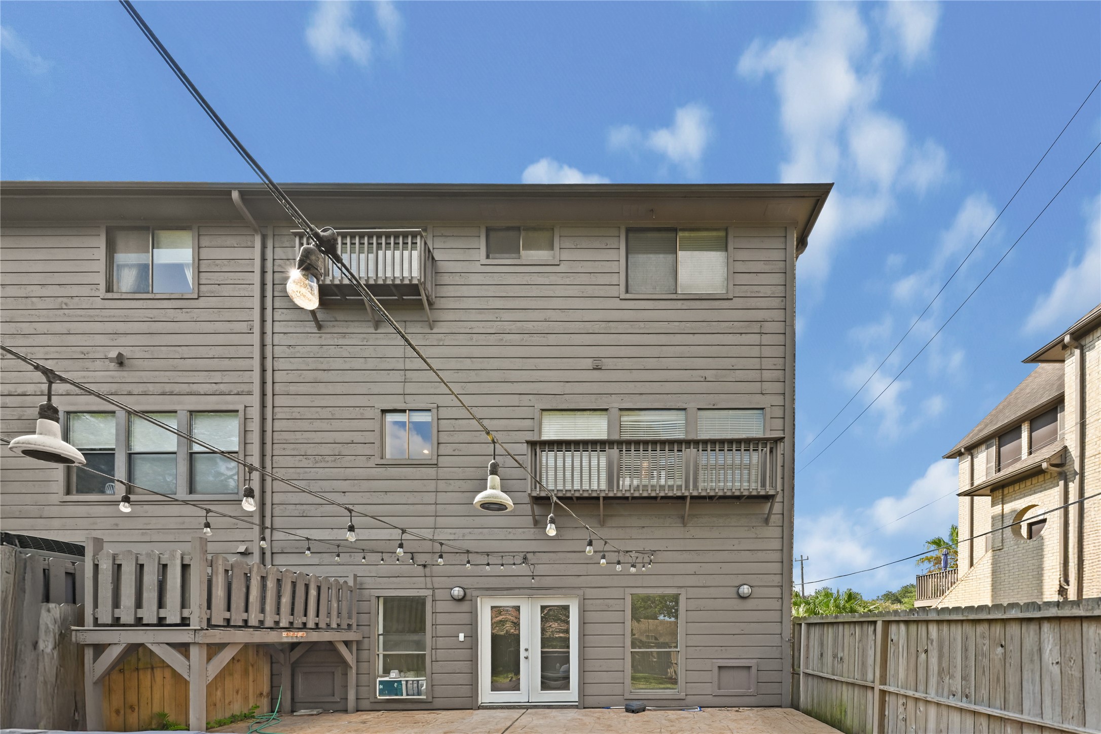 Open backyard with a wooden deck and charming string lights, perfect for entertaining or relaxing.