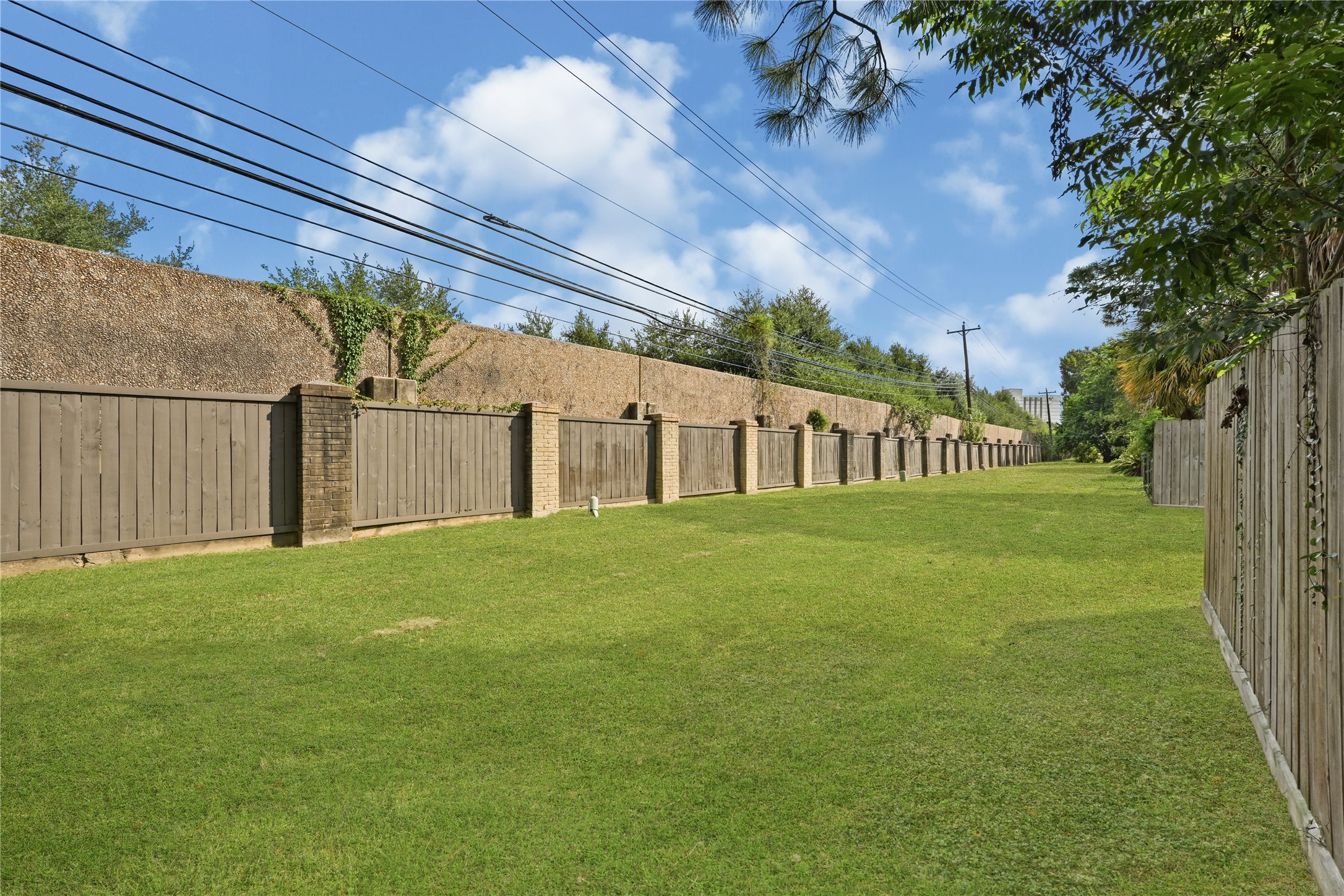 Well-maintained lawn area bordered by a sturdy wooden fence, offering privacy and a sense of openness.