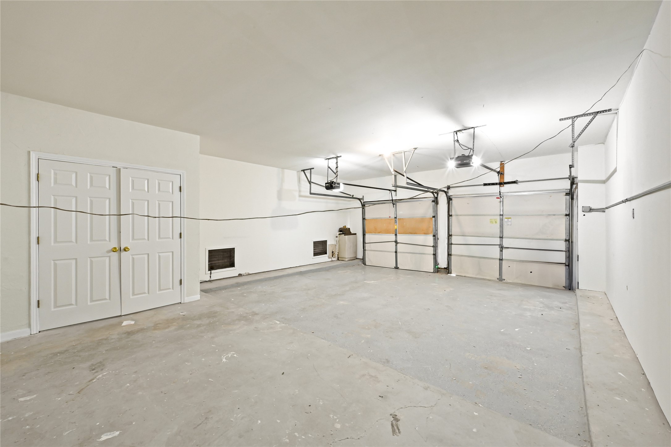 Spacious three-car garage with ample room for storage and easy access through dual doors.