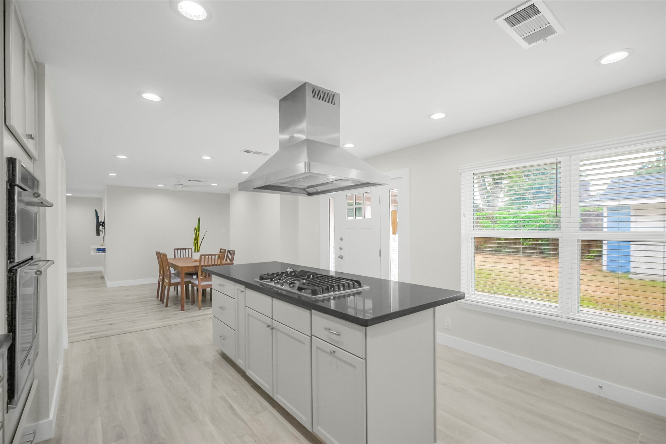 Third view of the kitchen shows the backyard and ample cabinets/storage.