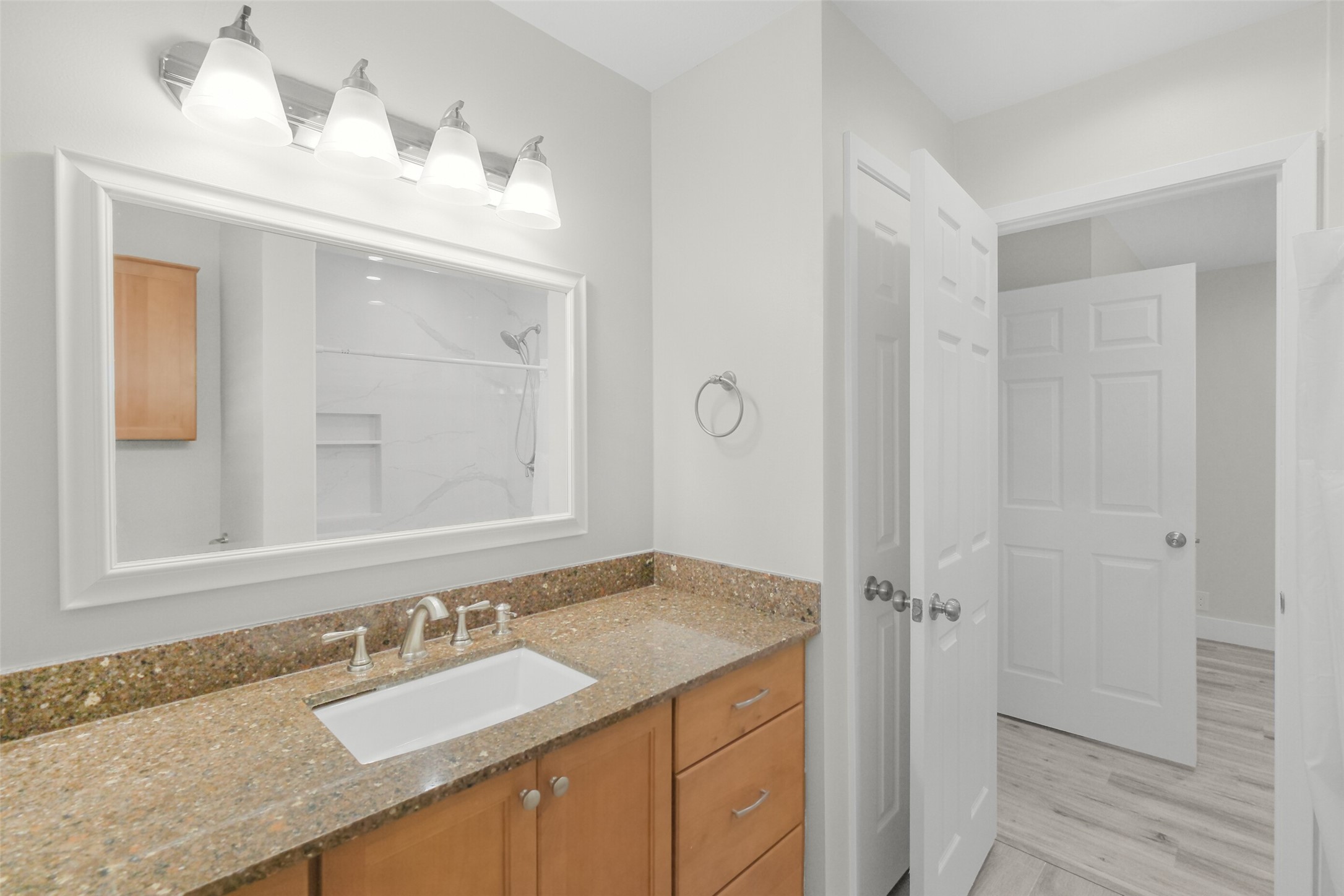 Full bathroom serving the second bedroom. Updated vanity, lighting and framed mirror.
