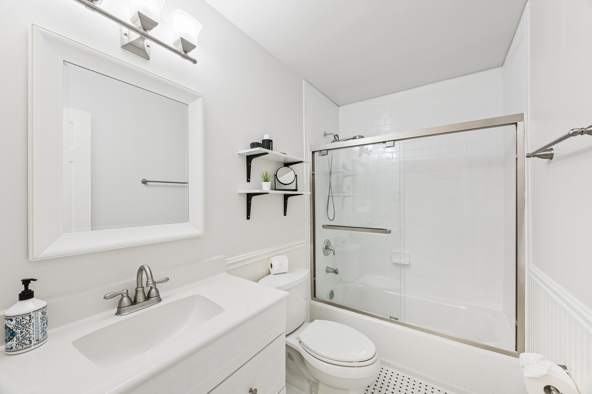 This bright and contemporary bathroom features sleek fixtures, a spacious vanity, and a modern glass-enclosed shower, offering a refreshing retreat in your new home.