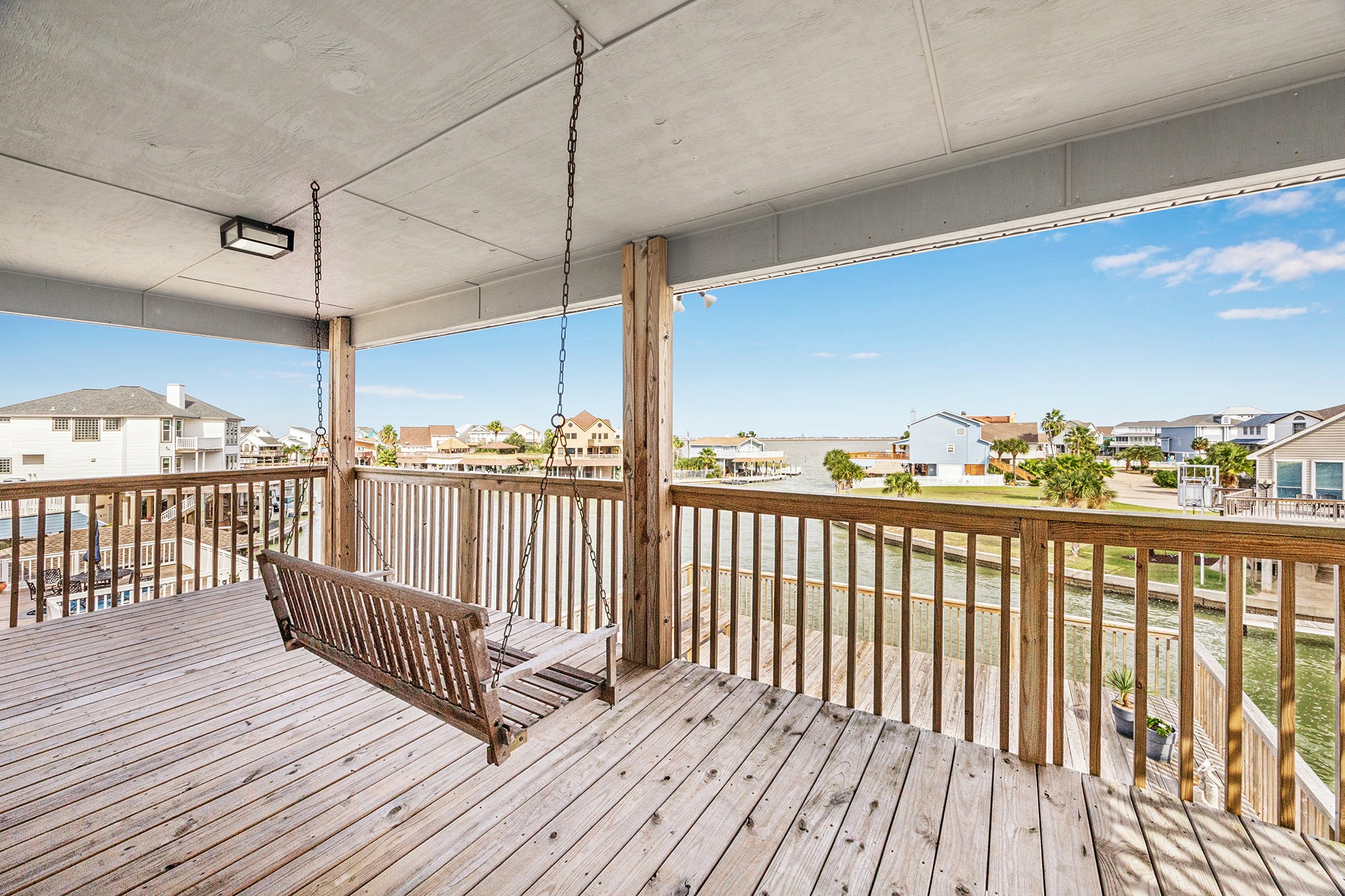 Enjoy serene waterfront views from this spacious outside deck, complete with a charming swing perfect for relaxing afternoons.