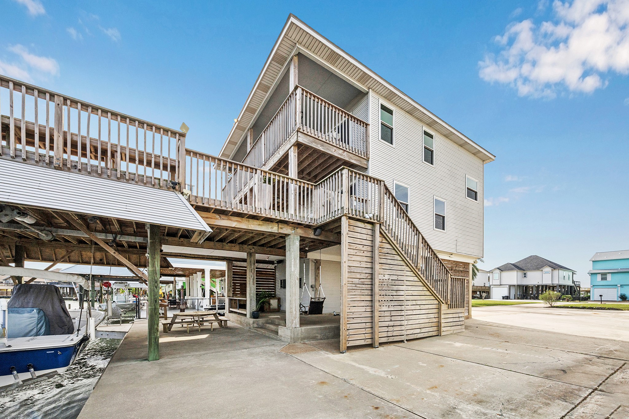 This stunning coastal home features an inviting side with expansive decking, perfect for enjoying waterfront views and outdoor living, complete with a spacious covered area for relaxation and entertainment.