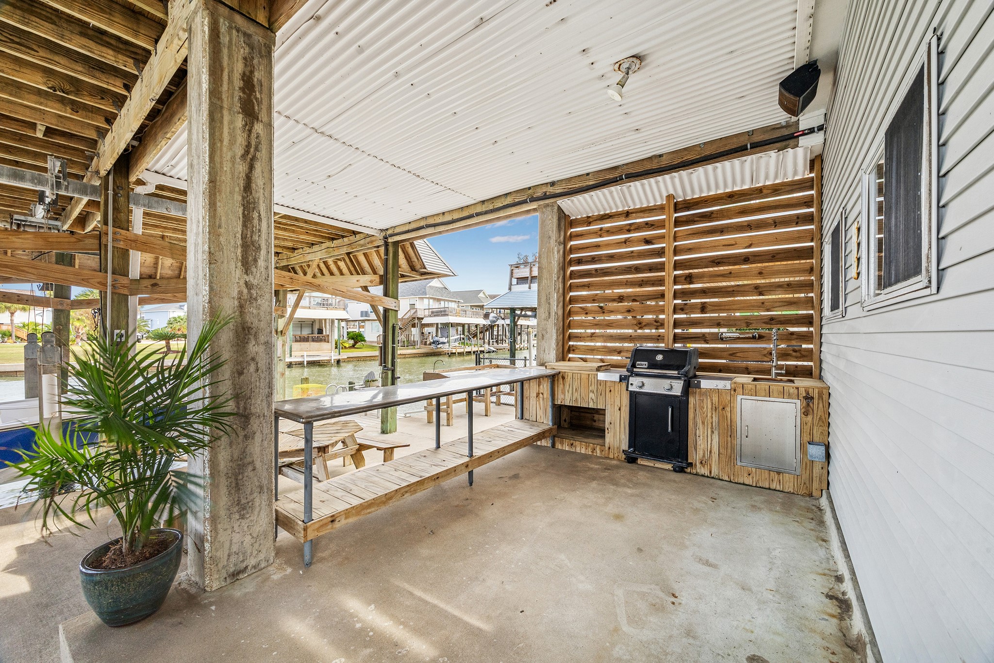 Discover the perfect outdoor oasis with a sleek grill and sink setup, ideal for entertaining while enjoying serene waterfront views.