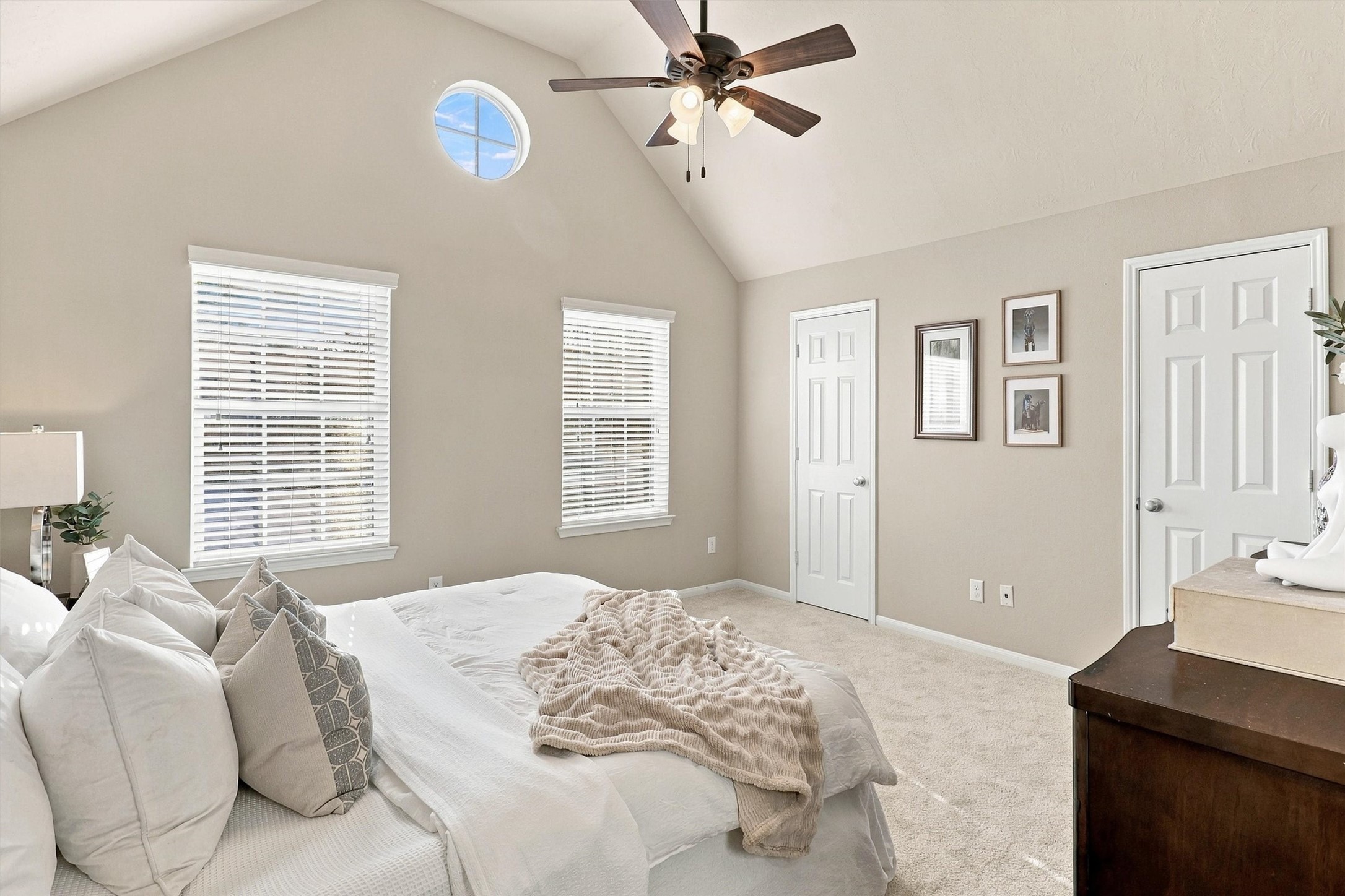 Welcome to your primary retreat! This primary bedroom is filled with natural light. The room features NEW carpet in a timeless color, vaulted ceilings, 3 bright windows, ceiling fan, walk-in closet, and en suite bath.