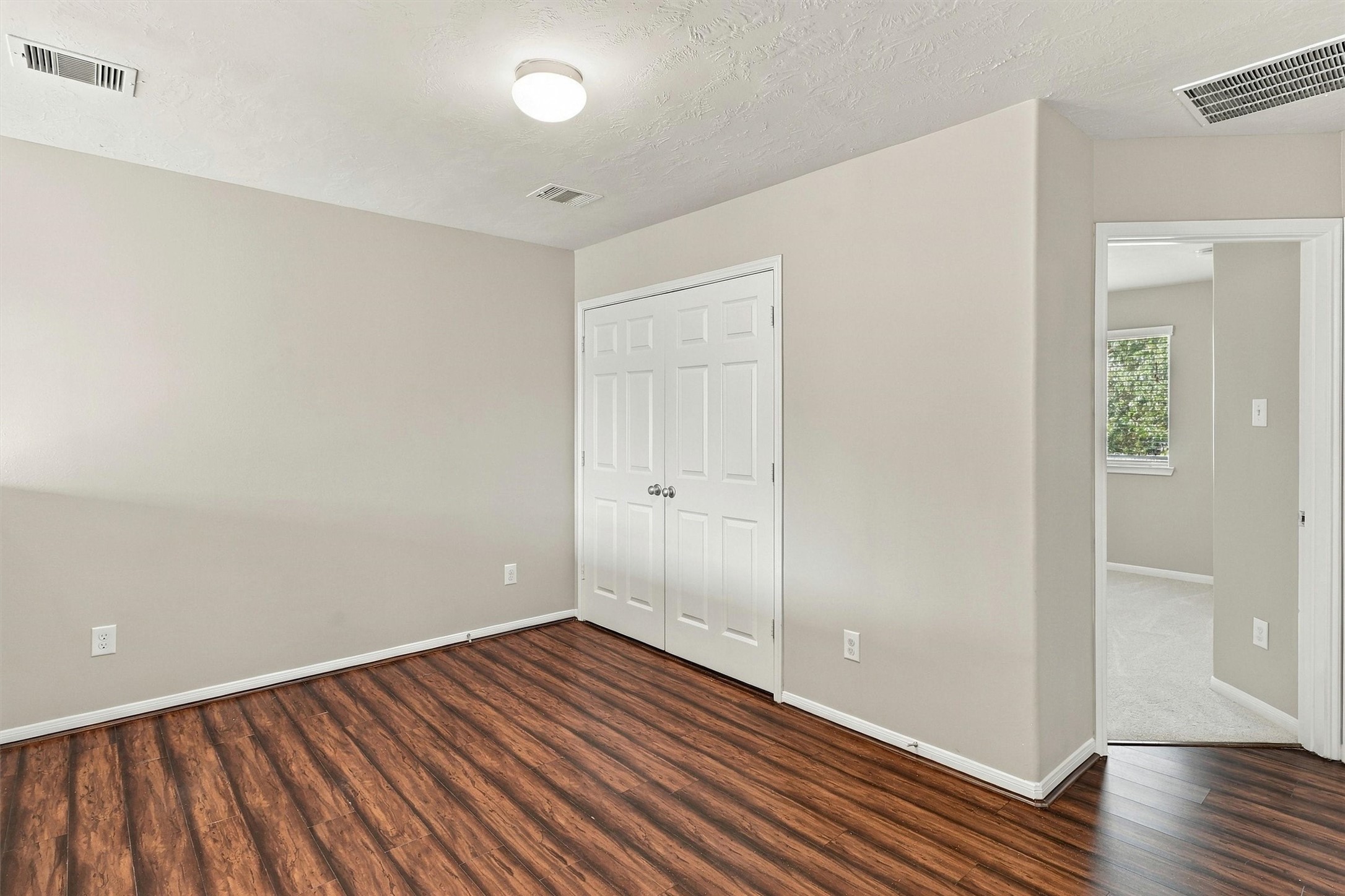 Alternate view of the game room highlights the wood laminate floors, refreshed paint, and double doors that open to the laundry room.