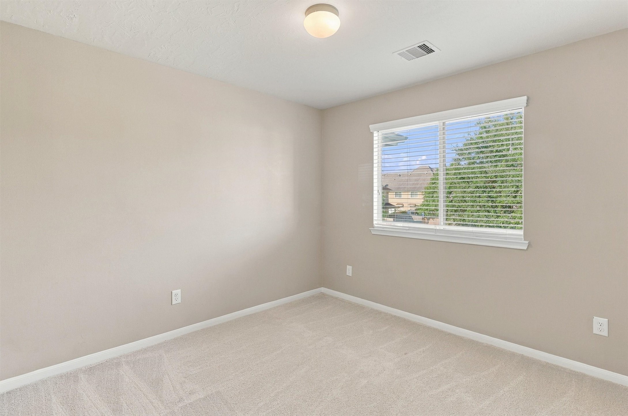 The third bedroom features NEW carpet, refreshed Sherwin Williams Paint, double pane window overlooking the community park, and a bright light