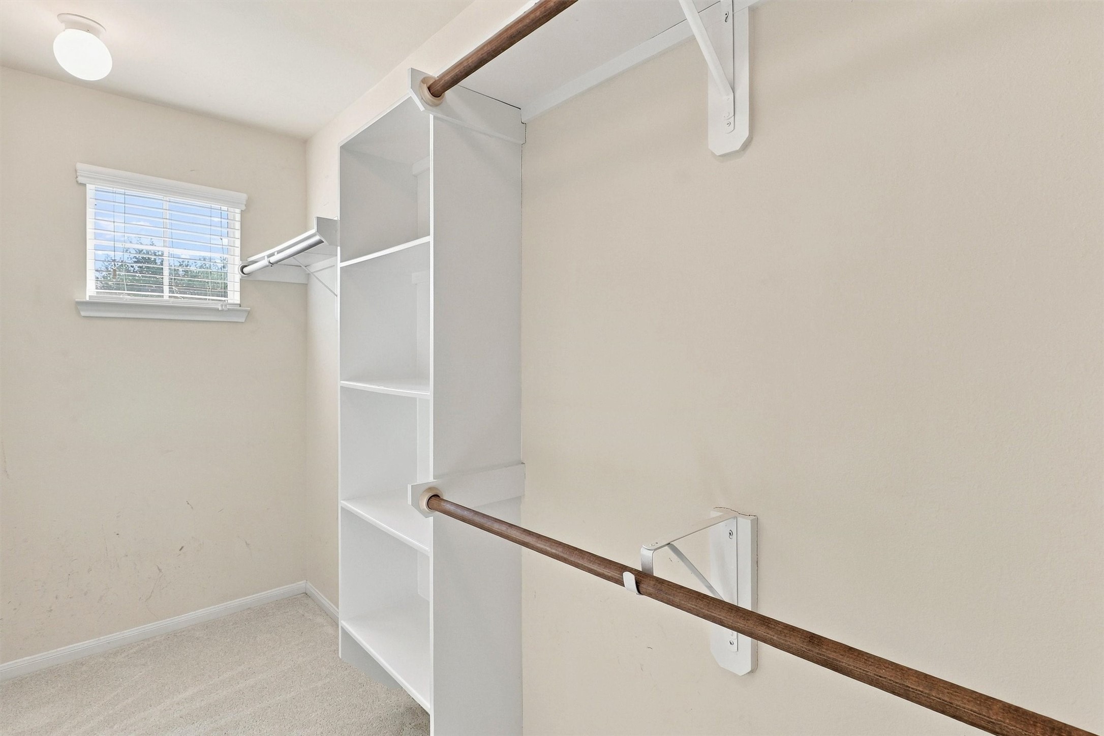 The walk-in closet features built-in shelving, hanging racks, new carpet, and a petite window that lets natural light shine through.  There is plenty of space for your clothes, shoes, accessories, and luggage!