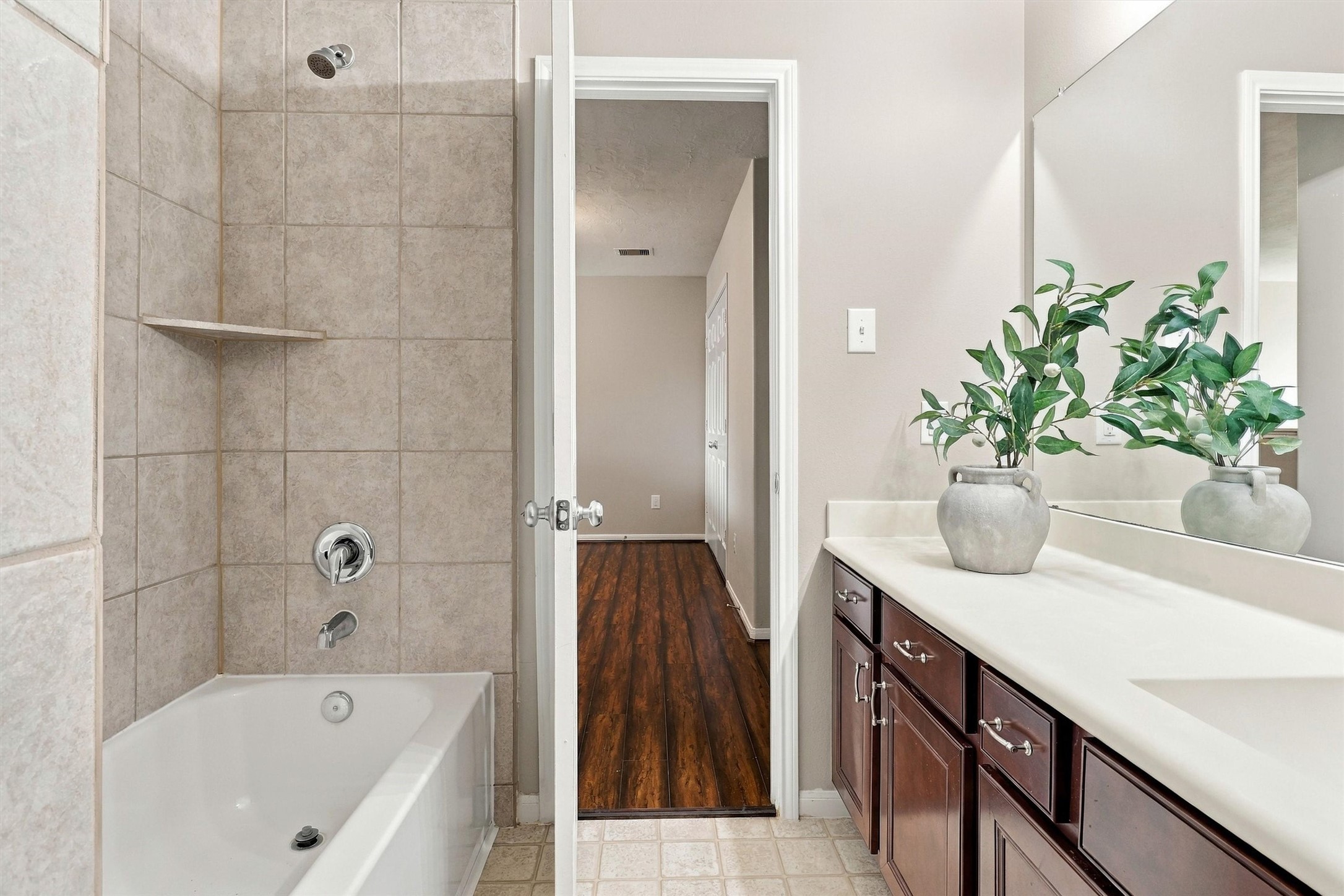 Alternate view of the bathroom highlights the tile surround and glittering chrome finishes.
