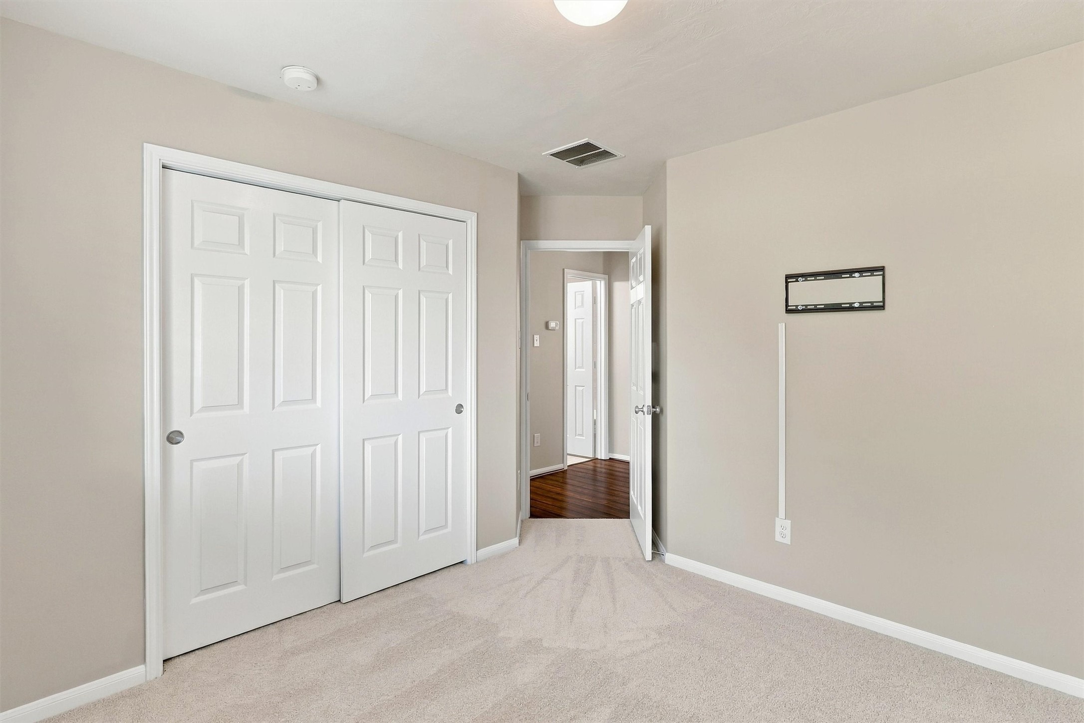 Double doors slide to reveal a deep reach in closet.