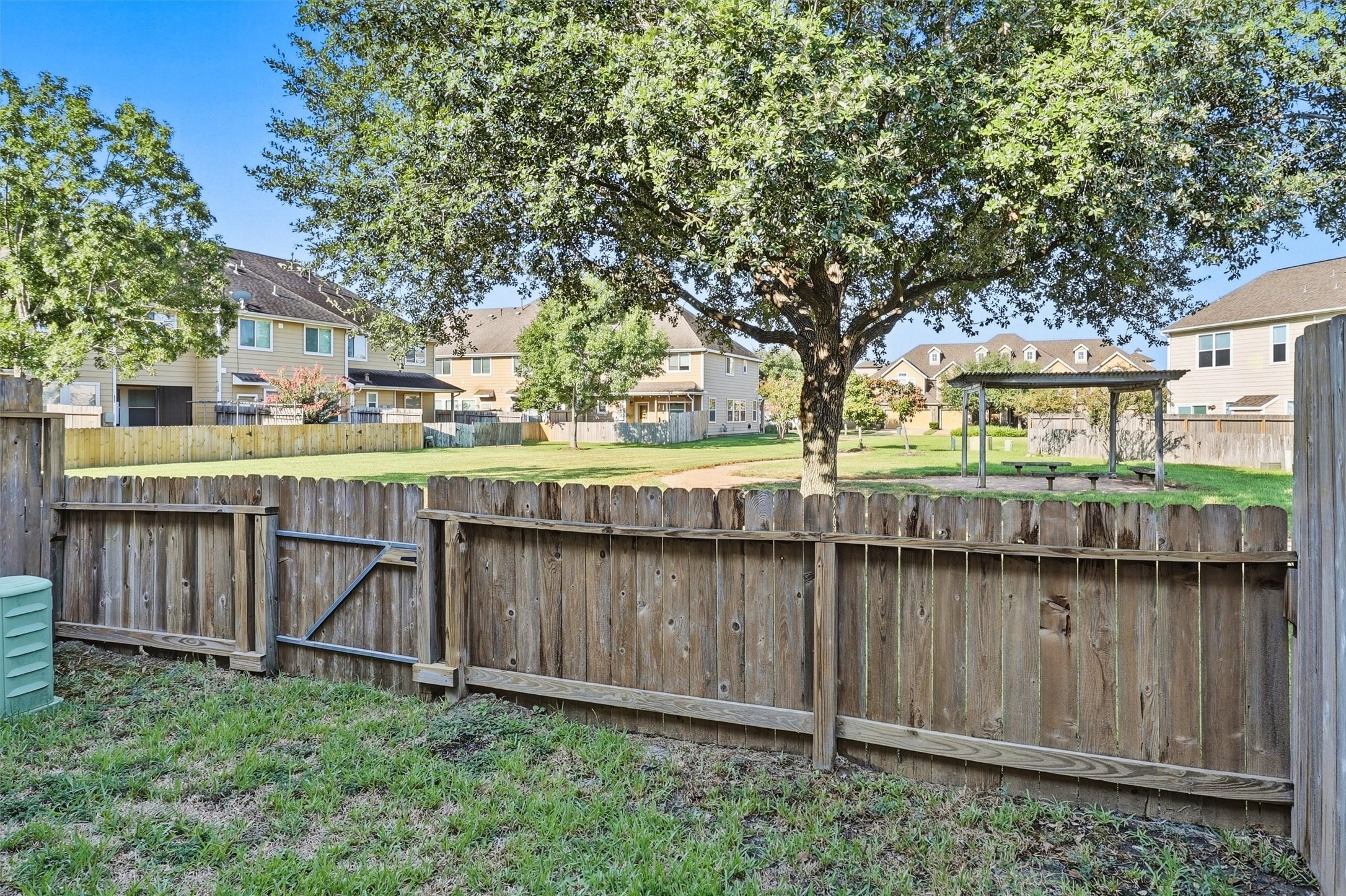 The half-height fence at the back of the townhome offer views of the wooded and serene community park!  Note the pergola and picnic table just outside your gate.  Low maintenance living, low insurance, and low property taxes are waiting for you at 8323 Lamond!