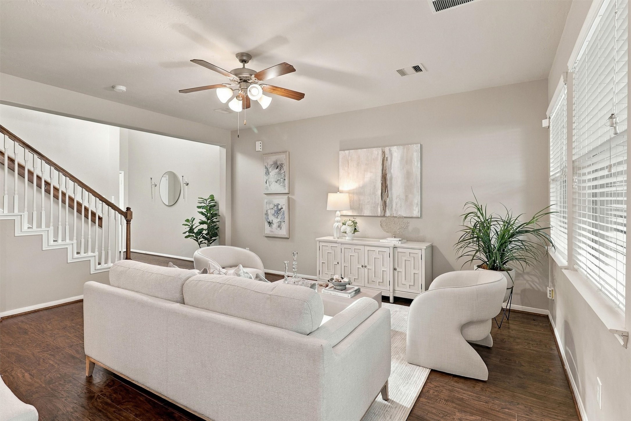 The living room features upgraded Sherwin Williams paint, wood laminate floors in a rich walnut color, crisp white trim, ceiling fan, and windows that let natural light flow through. There is plenty of space to set up your couch and occasional chairs.  The room is wired for cable and internet so that you can set up your media console on the longest wall.