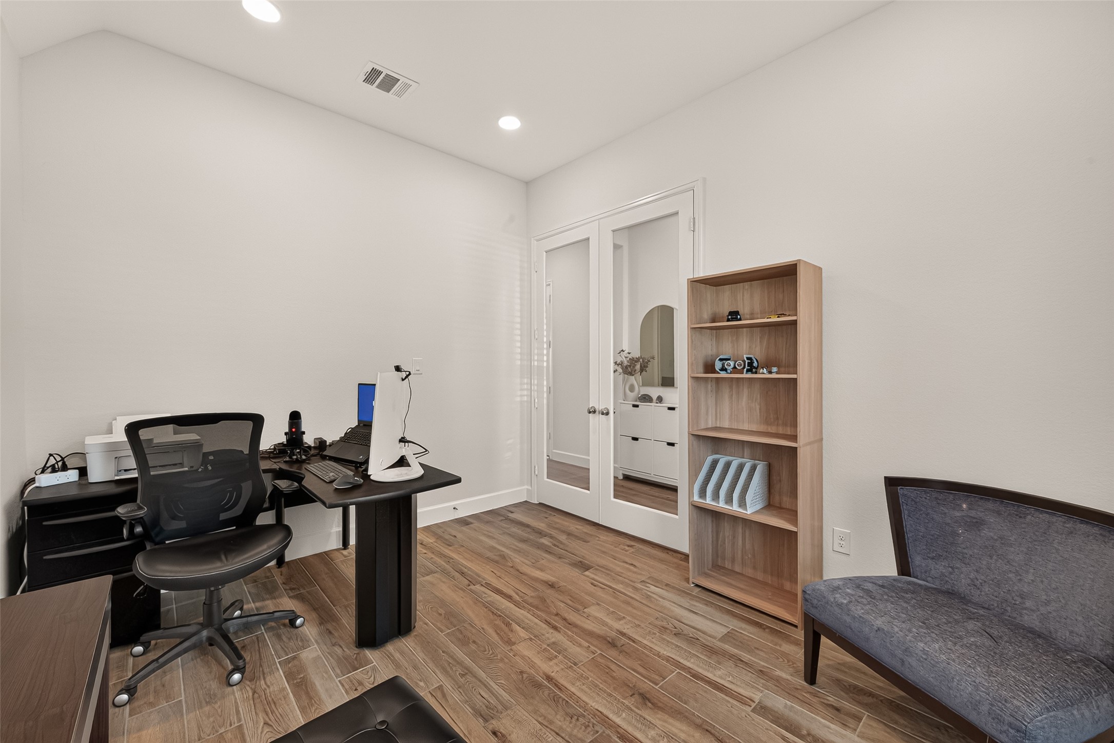 The office/studio is expansive enough to accommodate furniture arrangements; The light coming through the glass French doors is the perfect element for this office/studio.