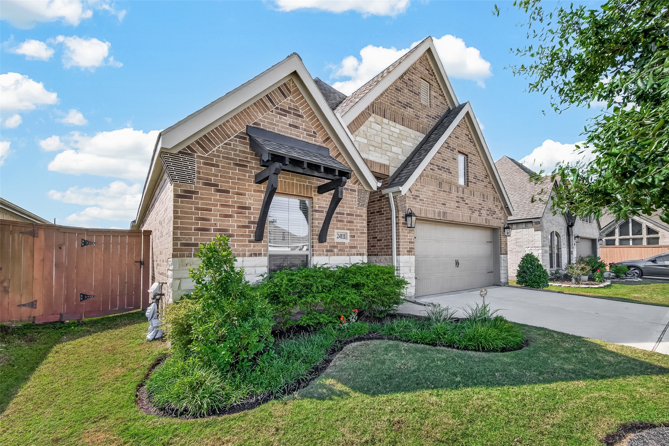This PERRY HOME has beautiful curb appeal including classic brick and stone elevation, manicured landscape, and a green front lawn with maturing trees.