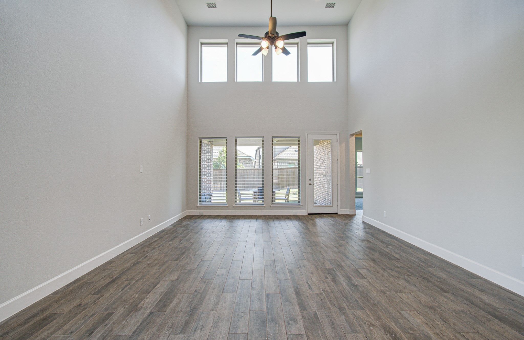 Expansive living area featuring soaring ceilings, abundant natural light from tall windows, and elegant flooring, creating a bright and inviting atmosphere.