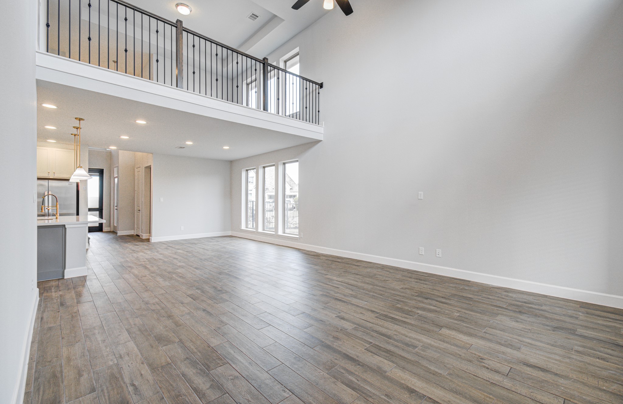 Spacious open-concept living area with high ceilings, elegant flooring, and abundant natural light. The modern kitchen features sleek finishes and pendant lighting, perfect for entertaining.
