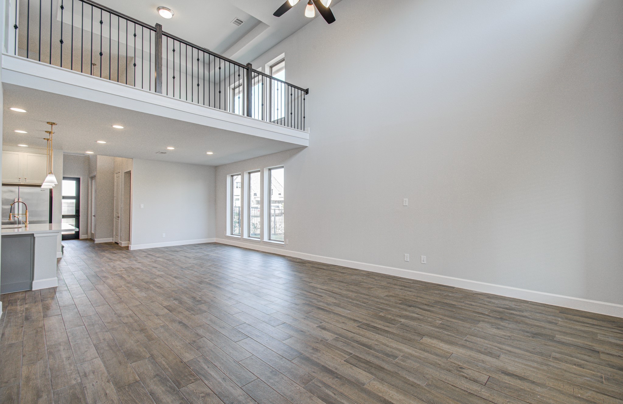 Stunning open-concept living/dining area with soaring ceilings, elegant flooring, and abundant natural light, complemented by a modern kitchen with a sleek design and stylish finishes.