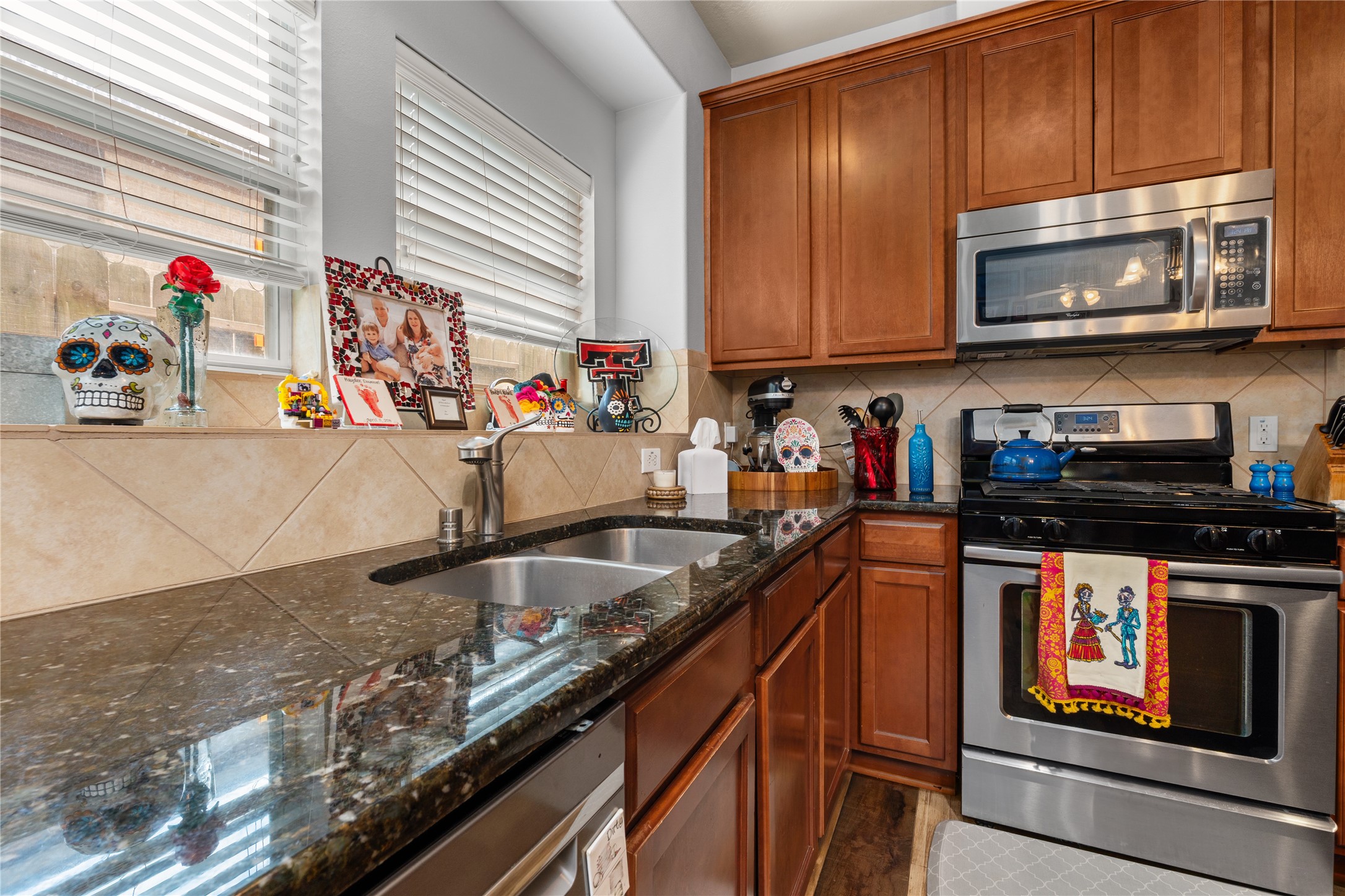 Charming kitchen with rich wooden cabinetry, sleek granite countertops, and stainless steel appliances.