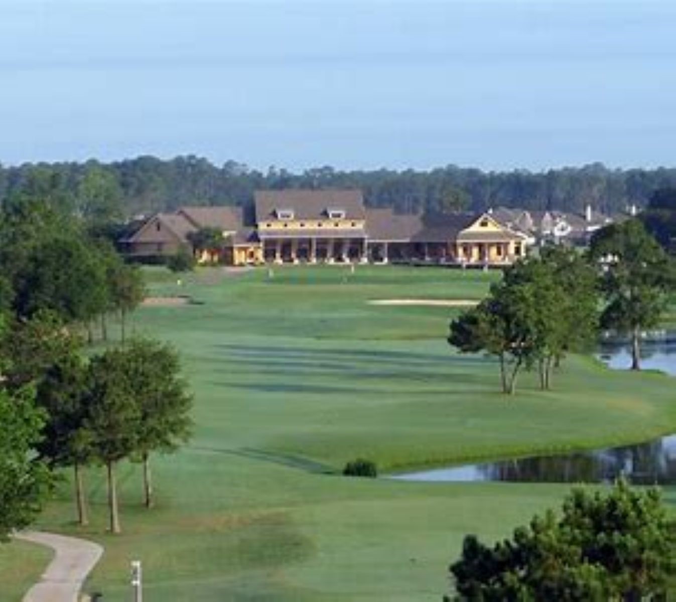 Expansive golf course views with lush greenery, a scenic water feature, and a charming clubhouse in the distance, perfect for golf enthusiasts seeking tranquility and elegance.